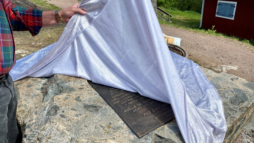 Duk dras av från sten med plakett.