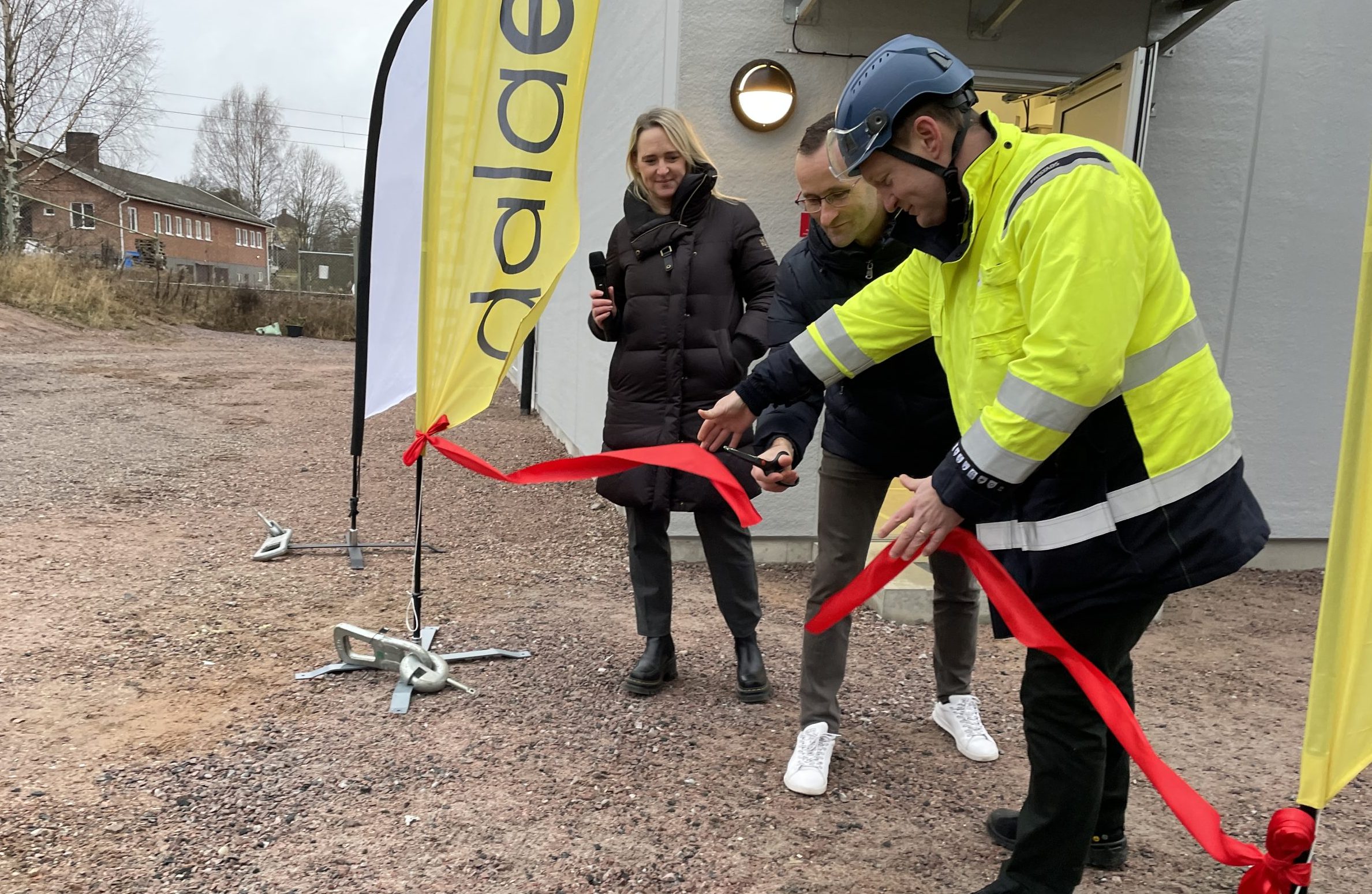 Ett rött band klipps av de ansvariga framför den nya byggnaden.