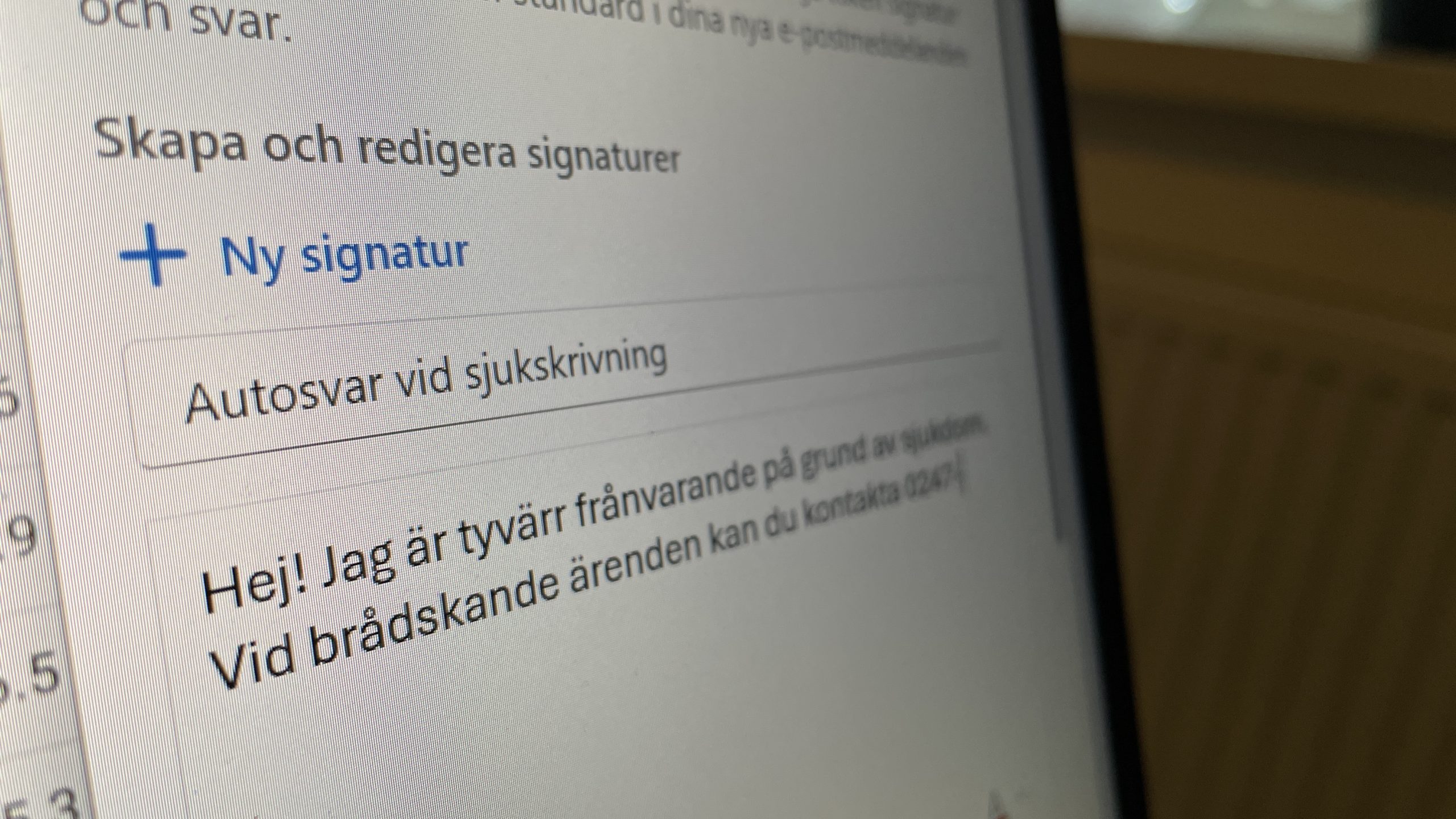 Text på en datorskärm: "Autosvar vid sjukskrivning: Hej! Jag är tyvärr frånvarande på grund av sjukdom. Vid brådskande ärenden kan du kontakta 0247-