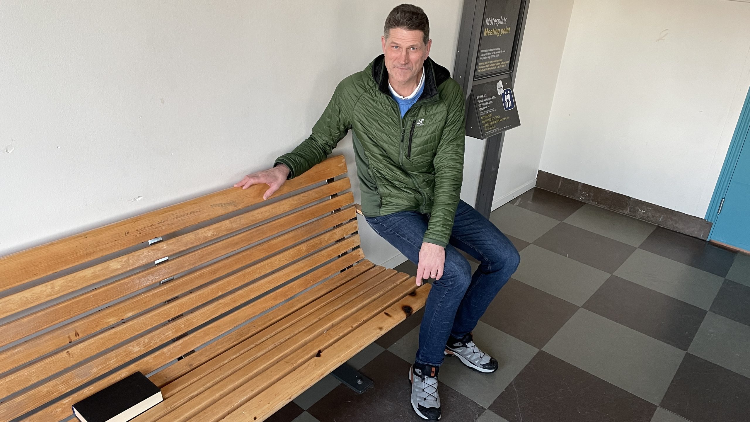 Man pekar på brännmärken på bänk i vänthall.