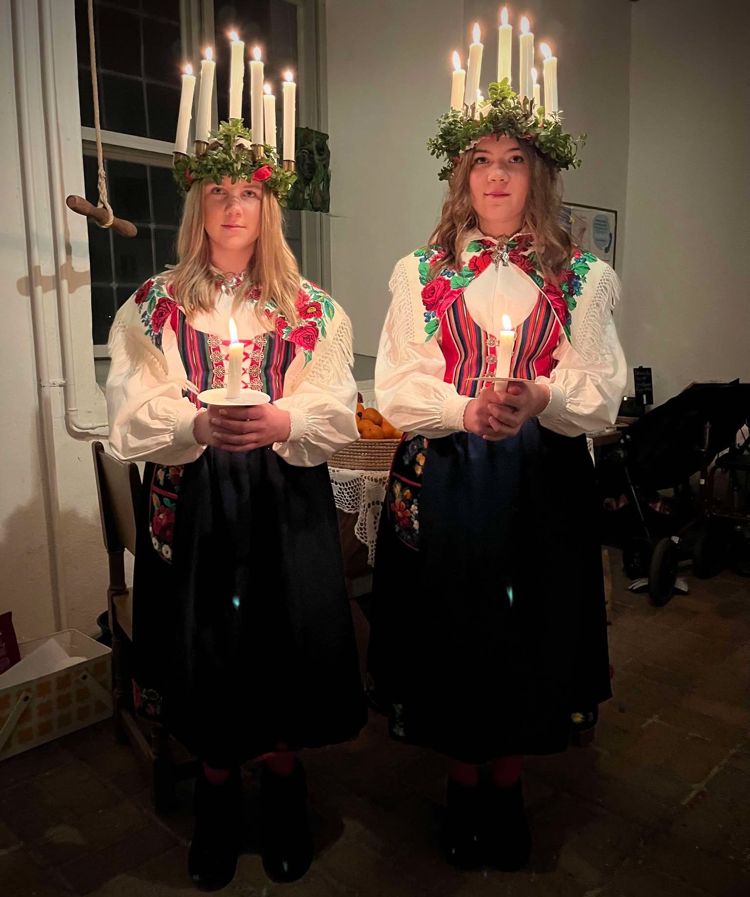 Två lucior i folkdräkt på en uppställd porträttbild