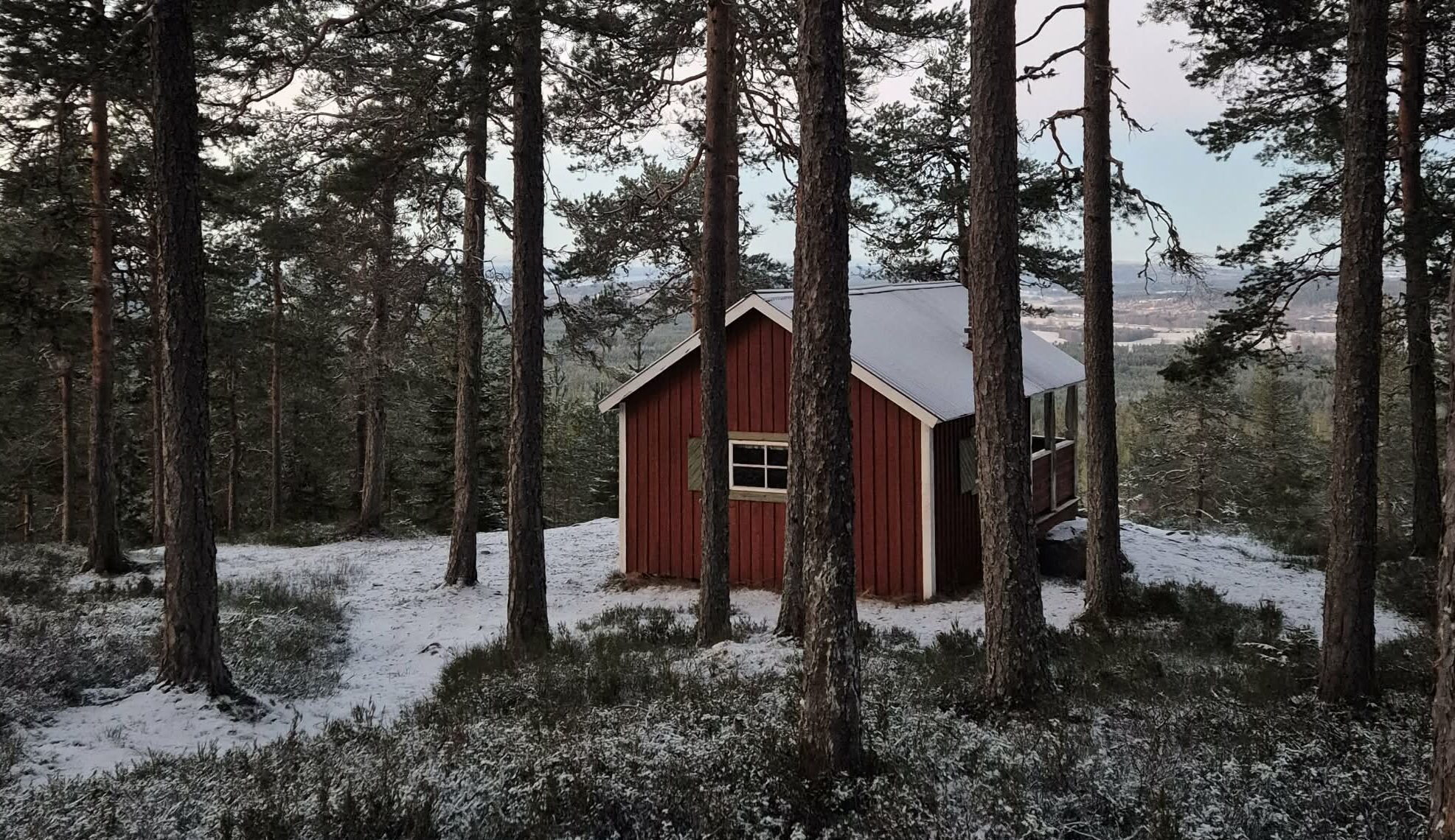 Lätt snötäcke på taket och marken vid Asaklittstugan