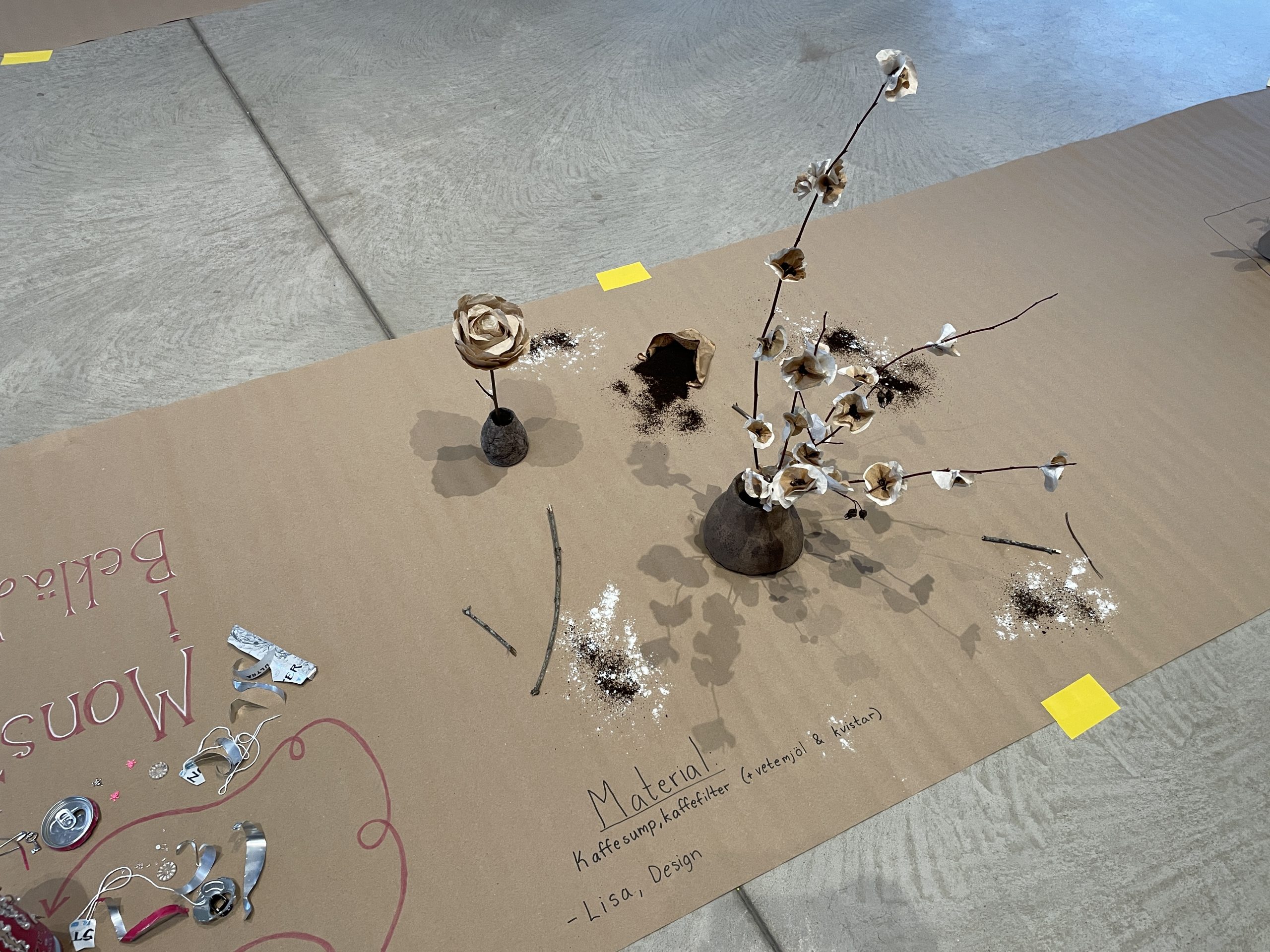 Blommor med använda kaffefilter istället för blad, i en kruka gjord av kaffesump.