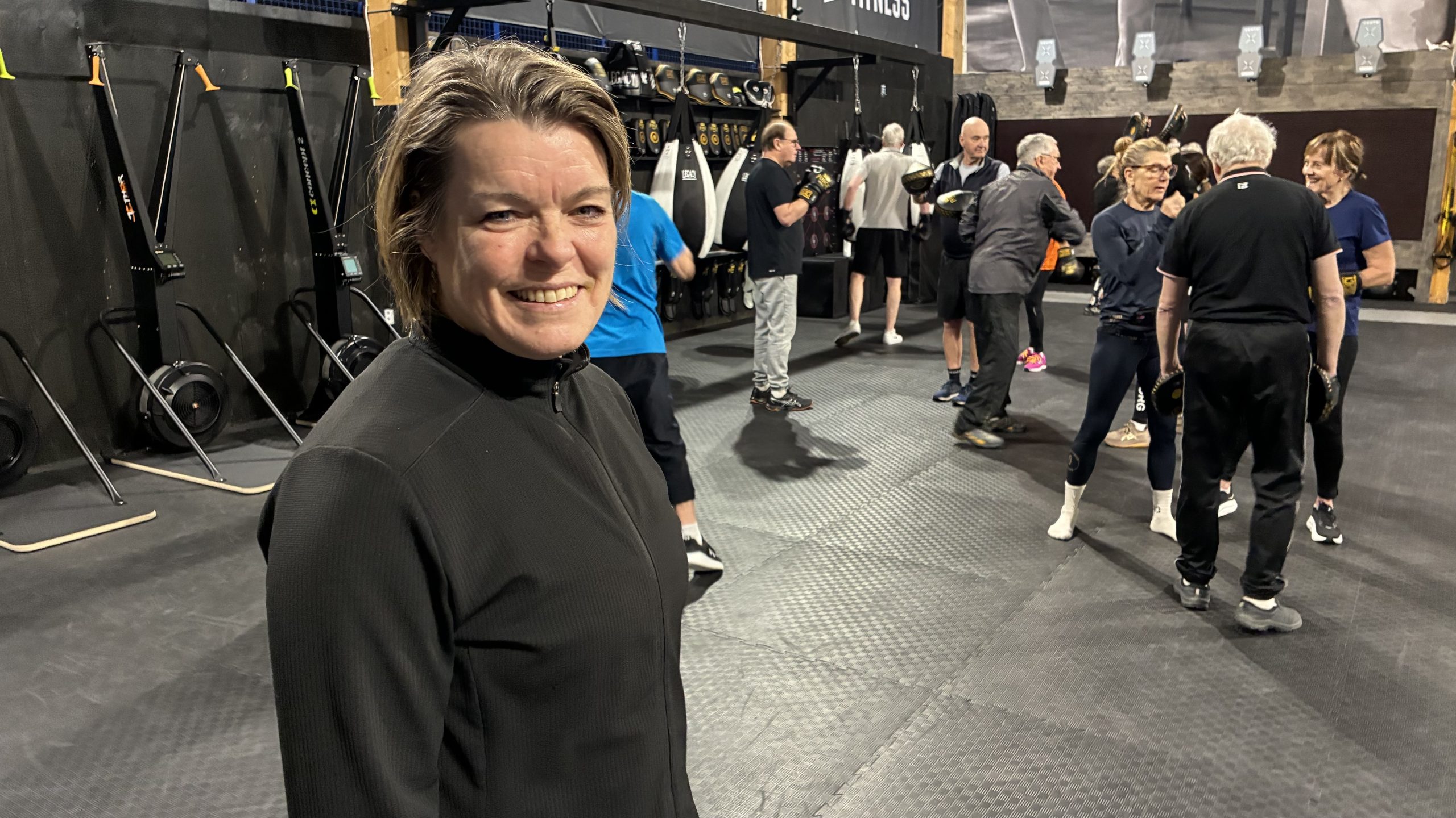 Projektledaren uppställd närmast kameran, med deltagarna i bakgrunden.