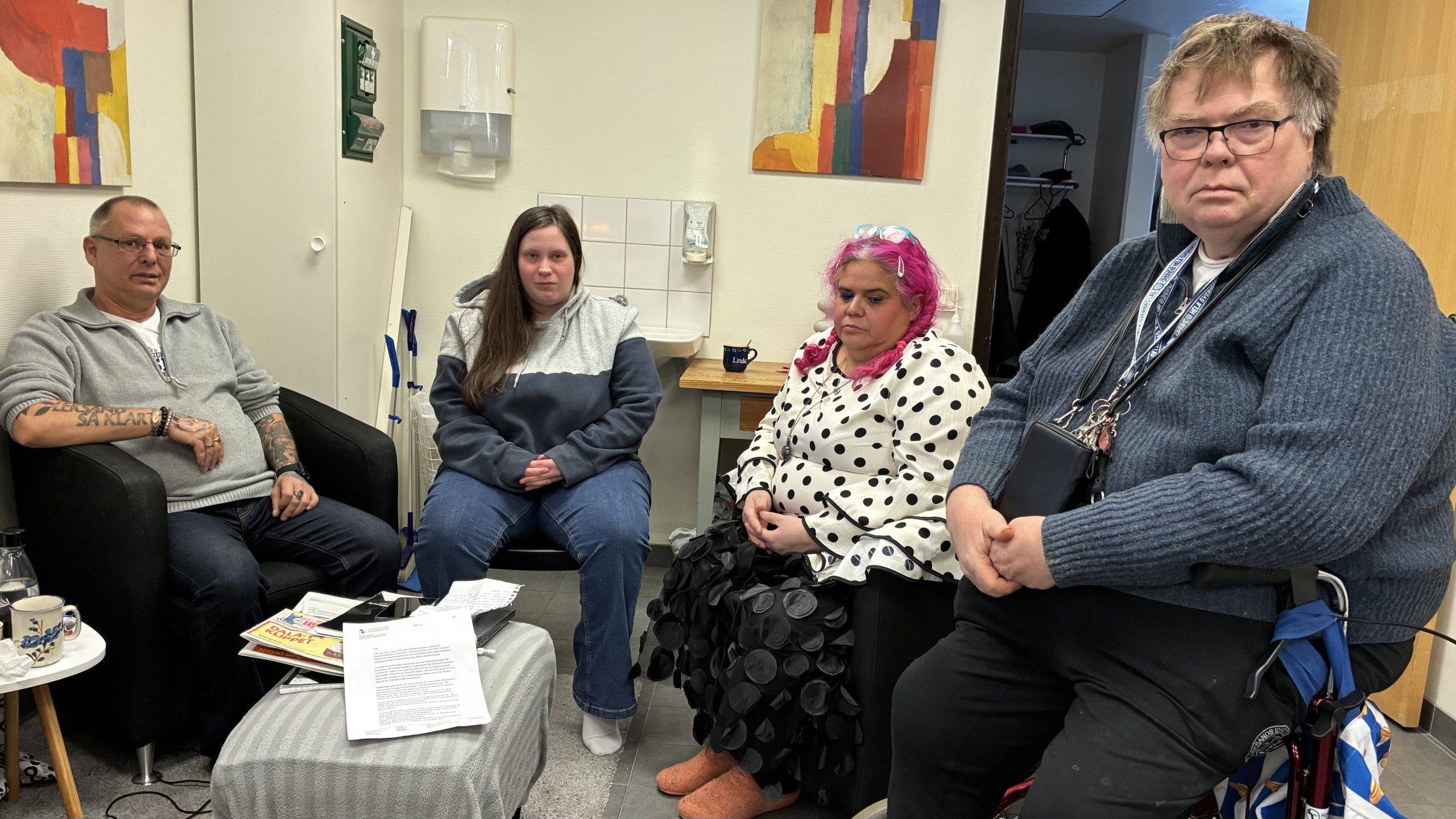 Fyra personer som sitter i en samlingslokal.