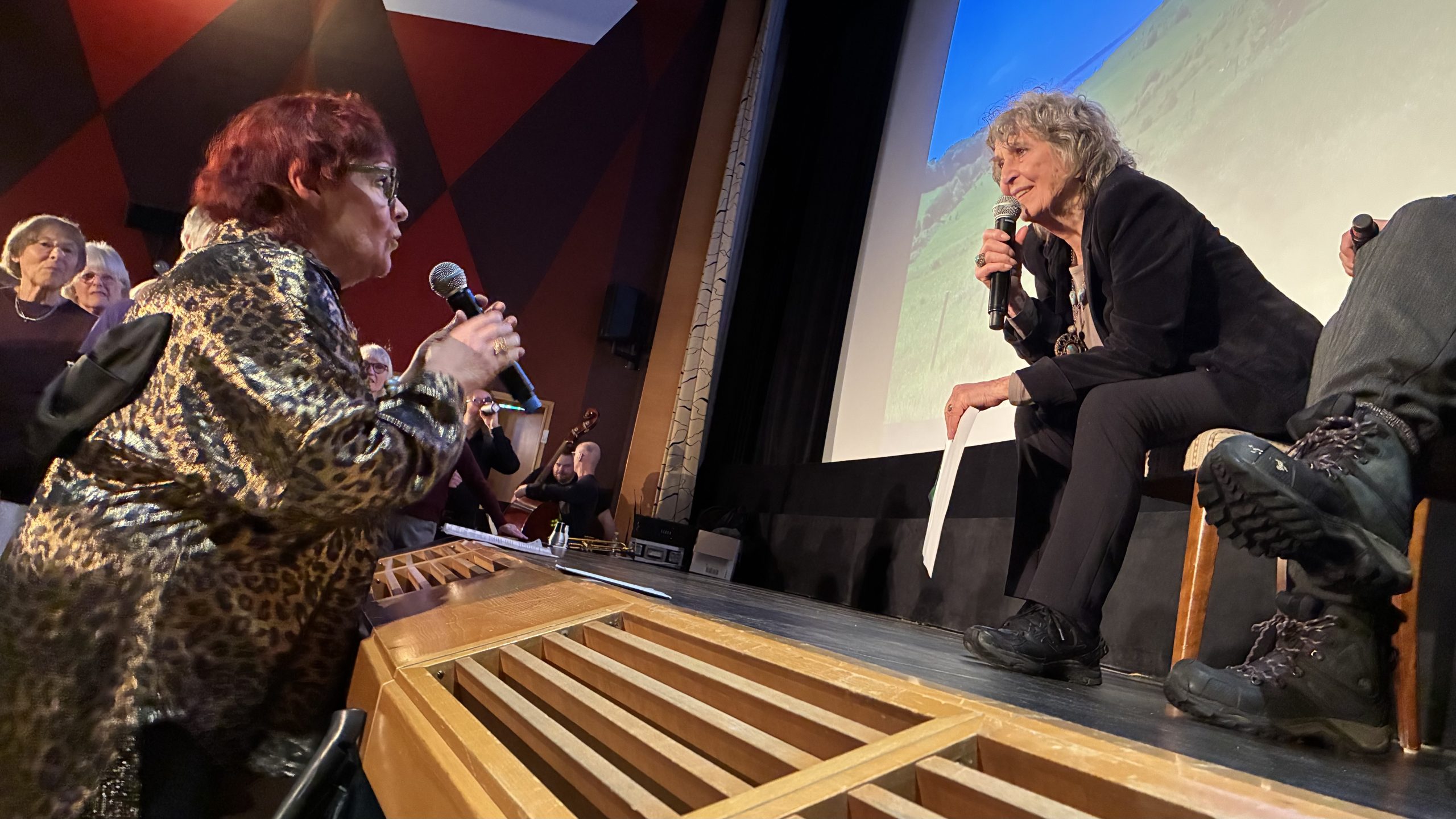 Person som står vid scenkanten pratar i mikrofon till Siw på scenen.