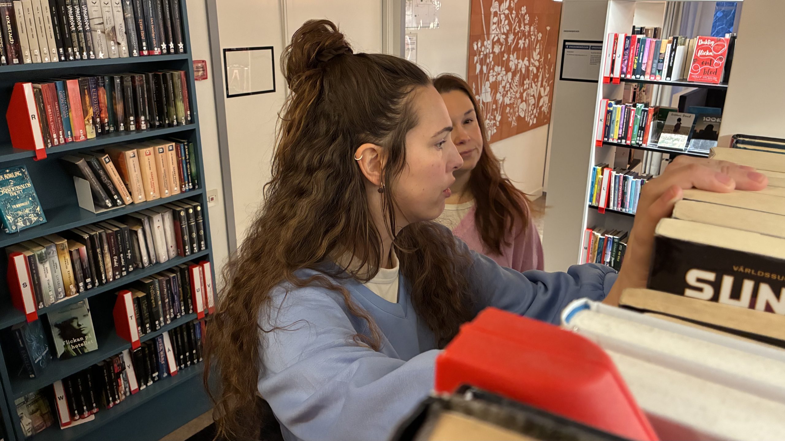 Bibliotekspersonalen letar bland hyllorna efter en bok.