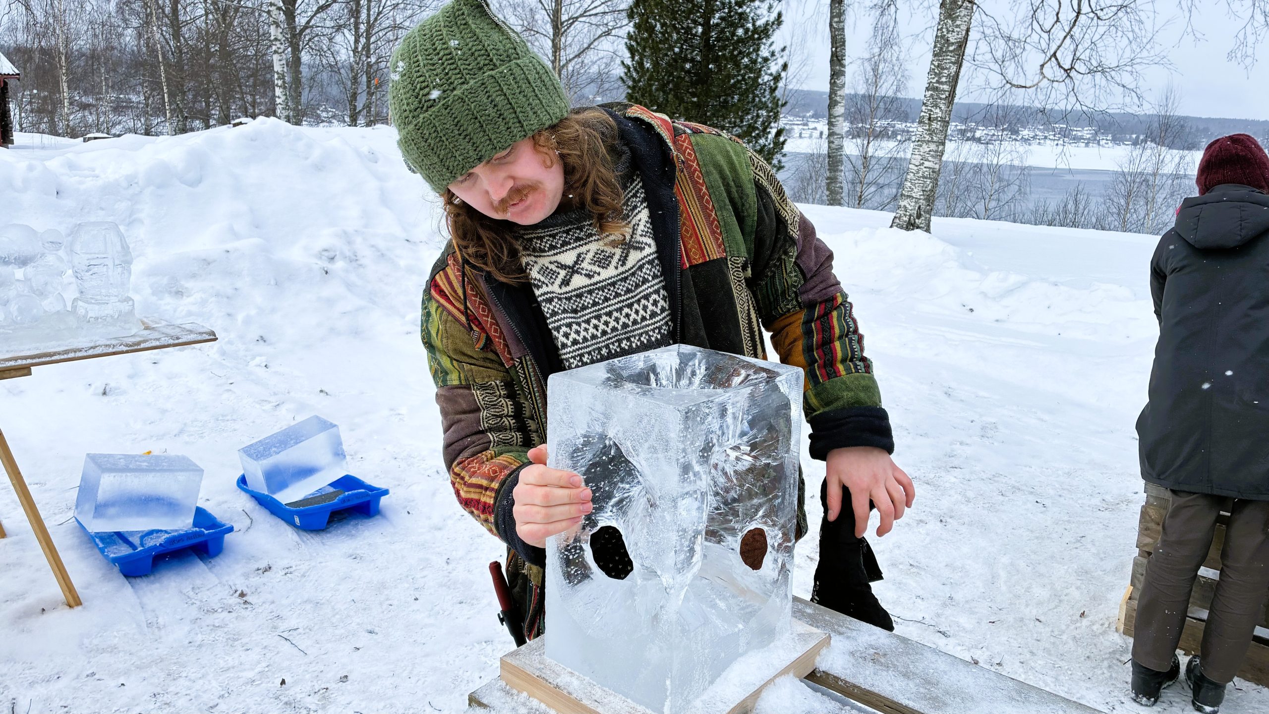 Man håller med handens fingrar direkt mot det kalla isblocket.