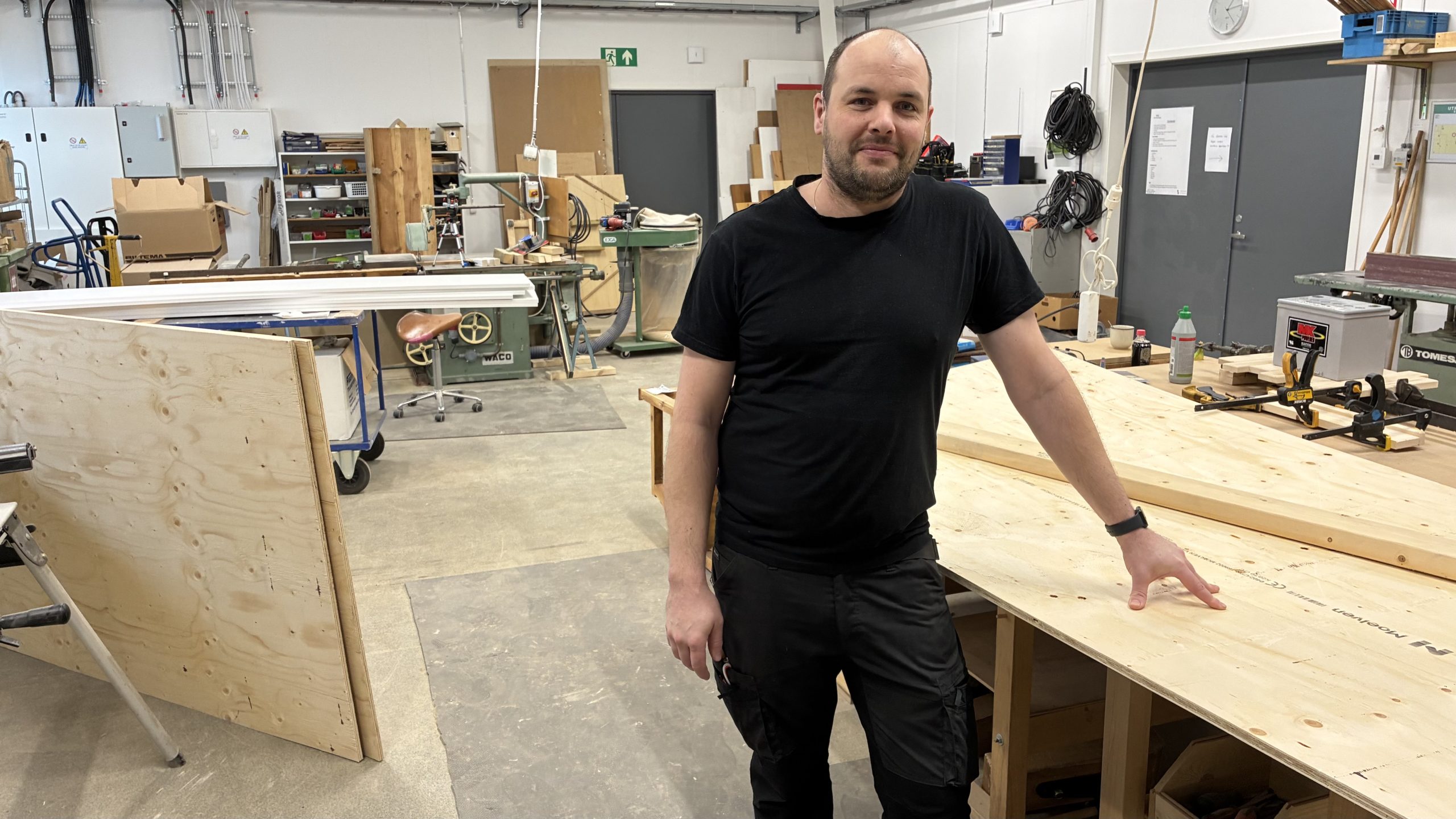 Tim Karg lutar sig mot ett arbetsbord i snickeriverkstaden.