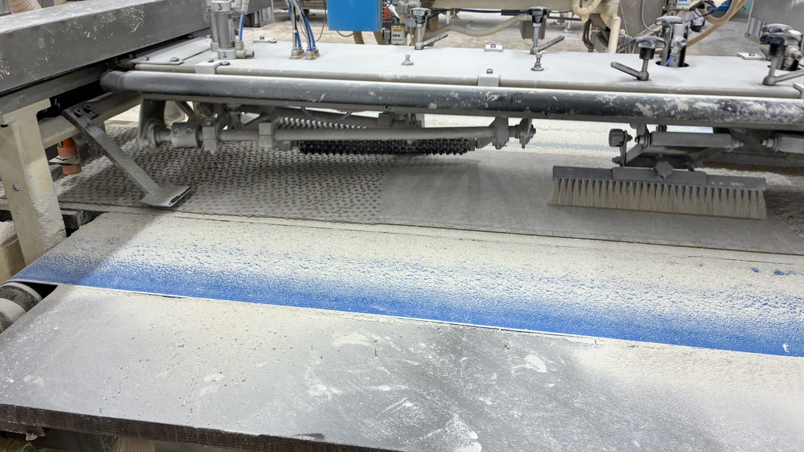 Maskin med en rulle som stämplar på fördjupningarna i degen.