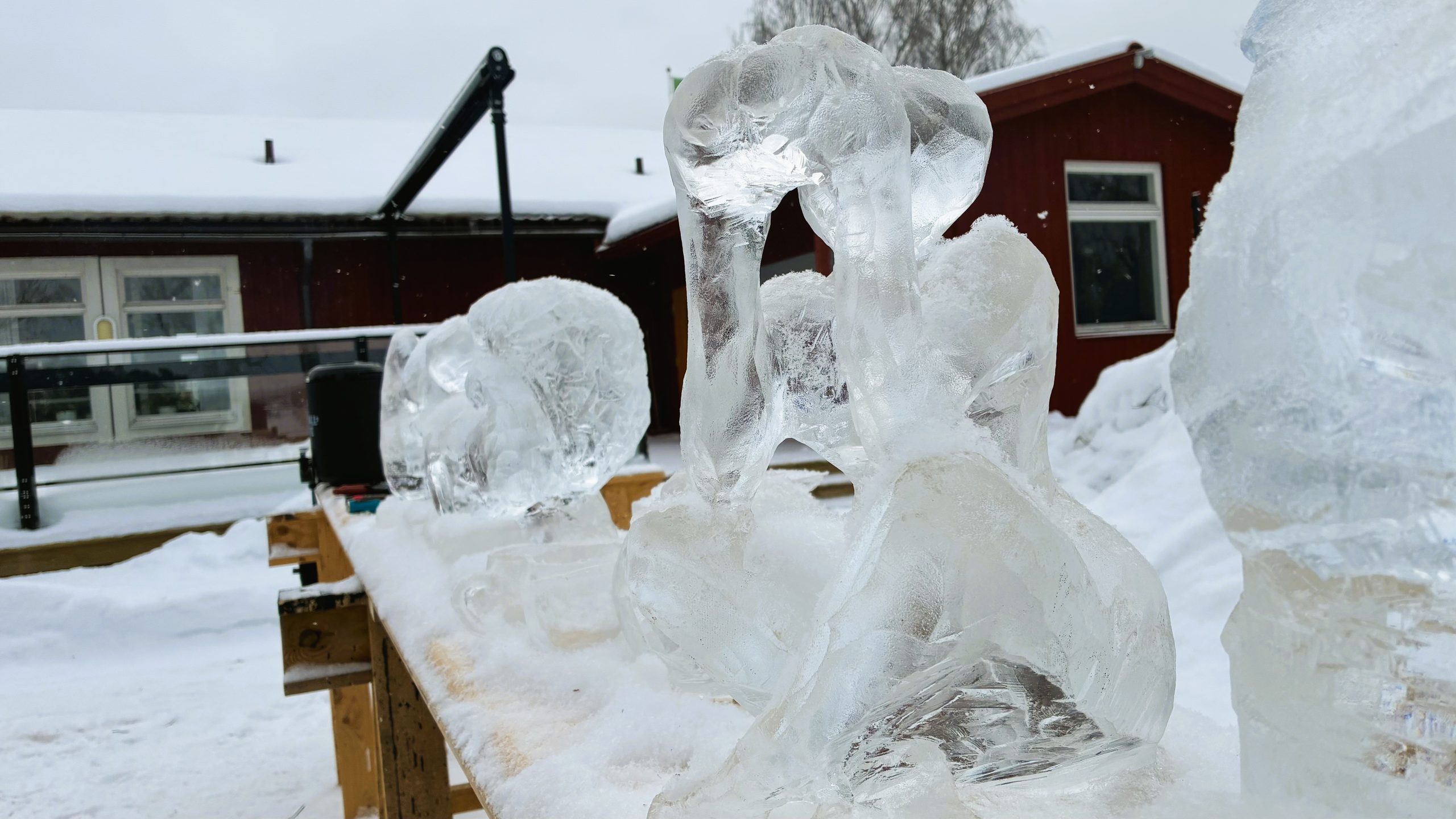Isskulptur av kvinna som tittar in i en kikare.