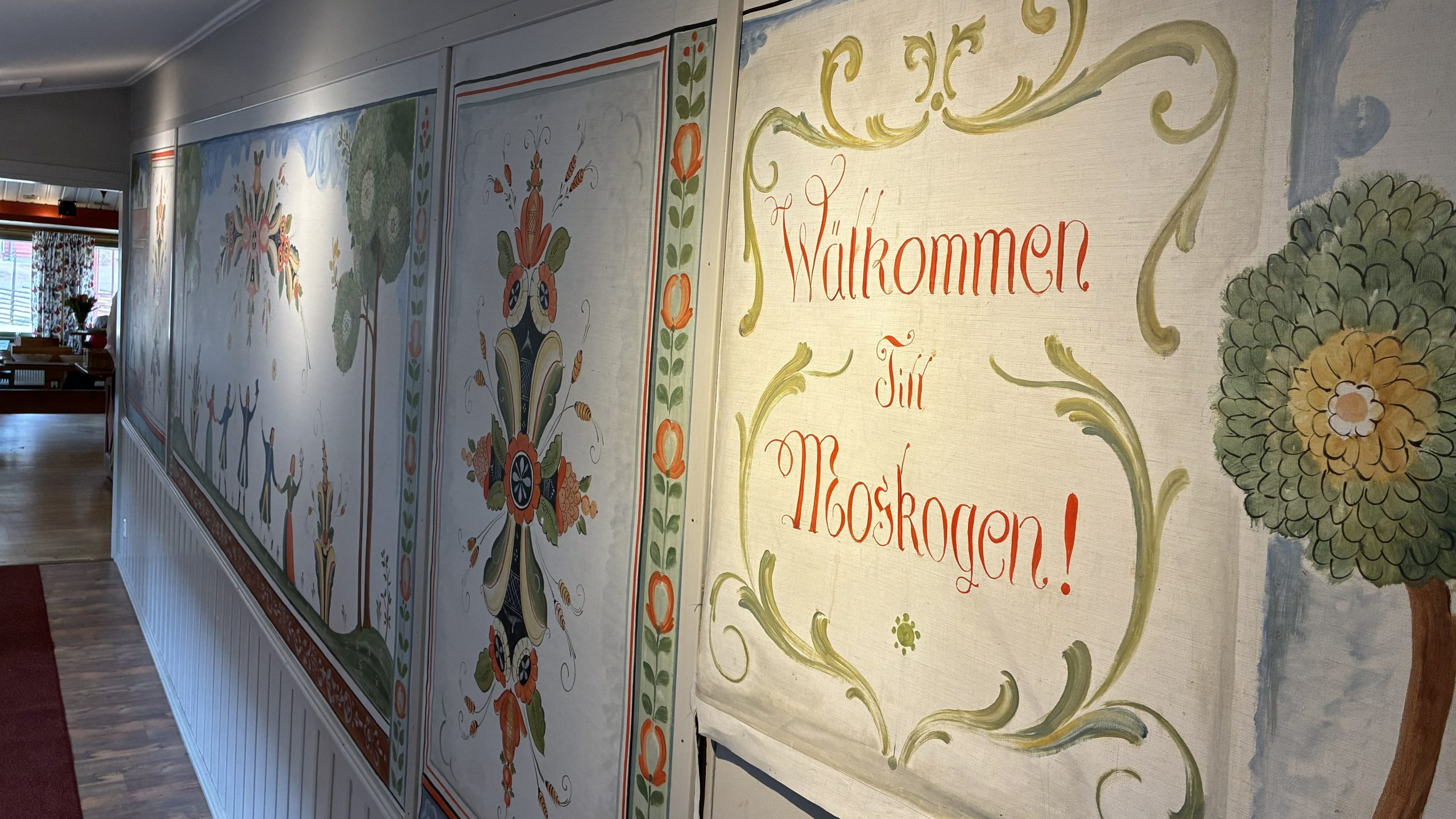 Gröna och röda kurbits med textstycket "Wälkommen till Moskogen" i fokus.