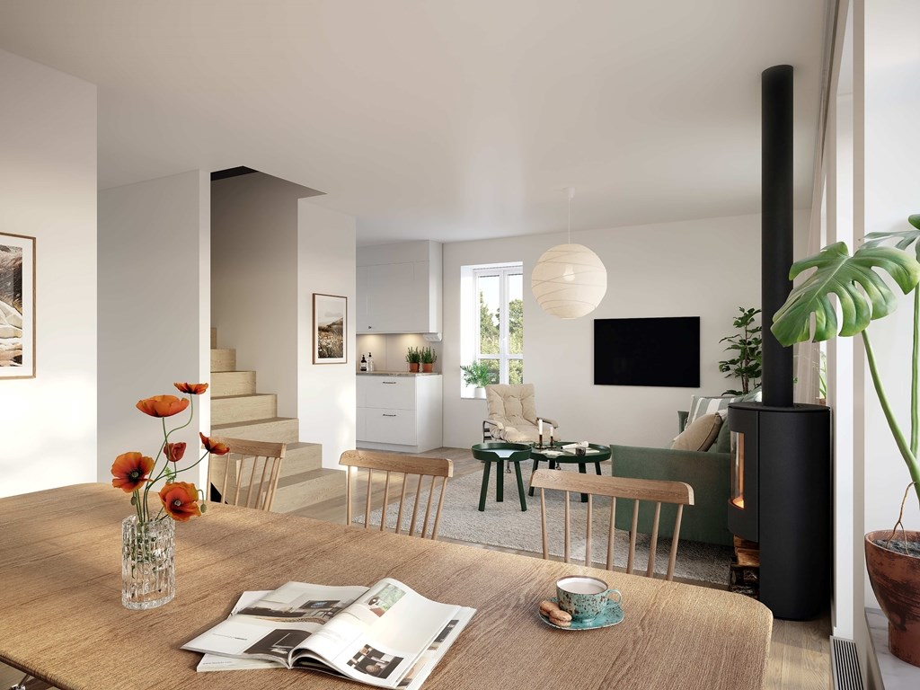 Ljust vardagsrum med braskamin och trappa till övervåningen.