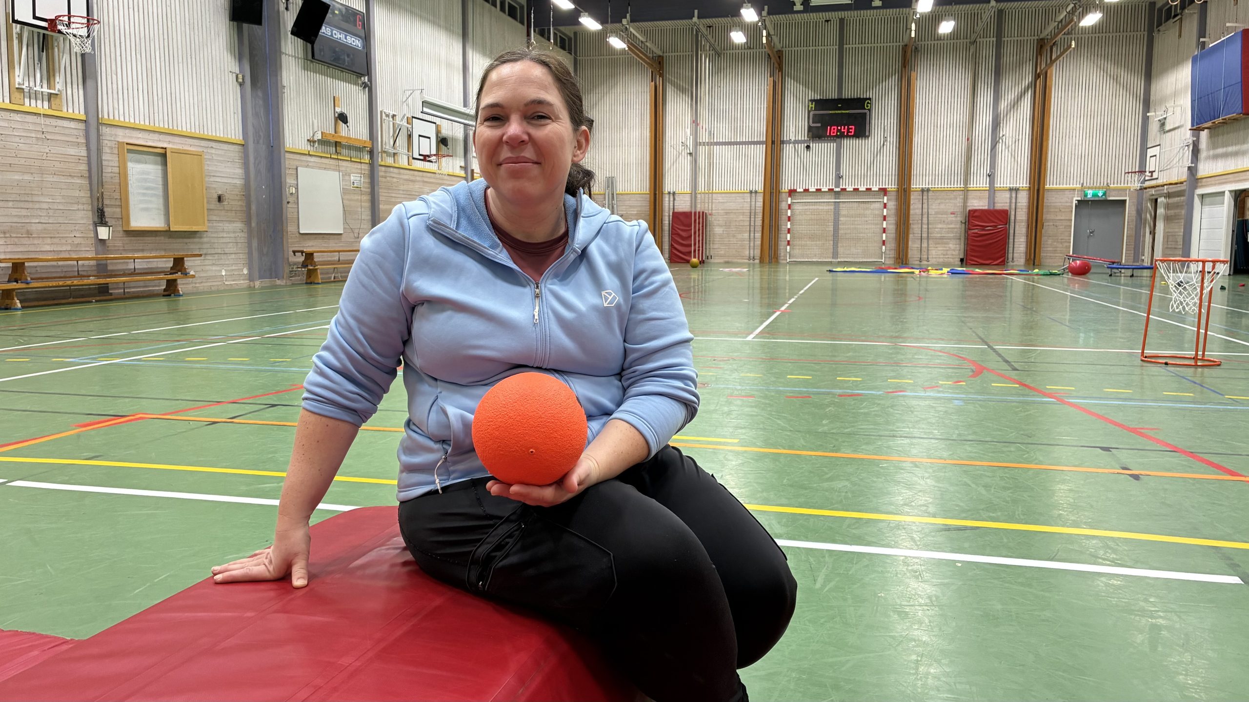 Nikolett Reicz sitter på en madrass med en mjuk boll i famnen.