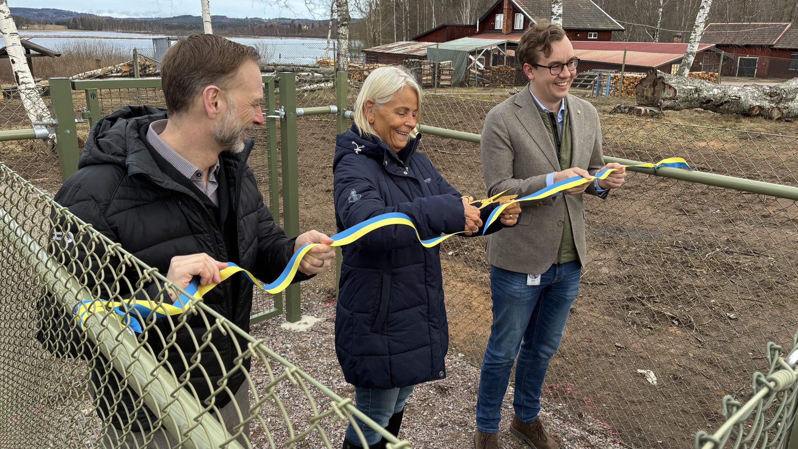 Bandet klipps av tre leende personer.