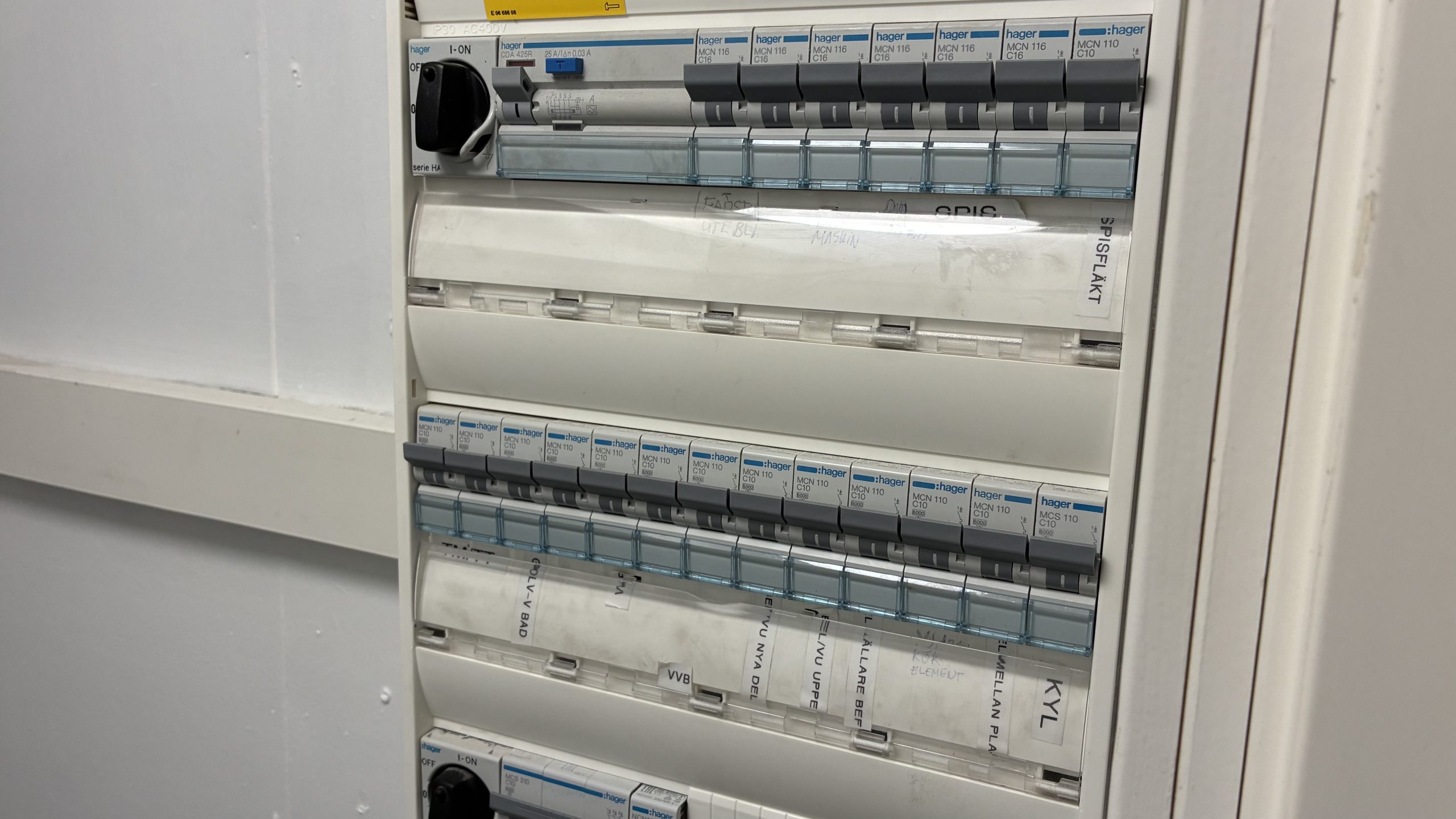 Närbild på elcentral eller säkringsskåp i en byggnad.