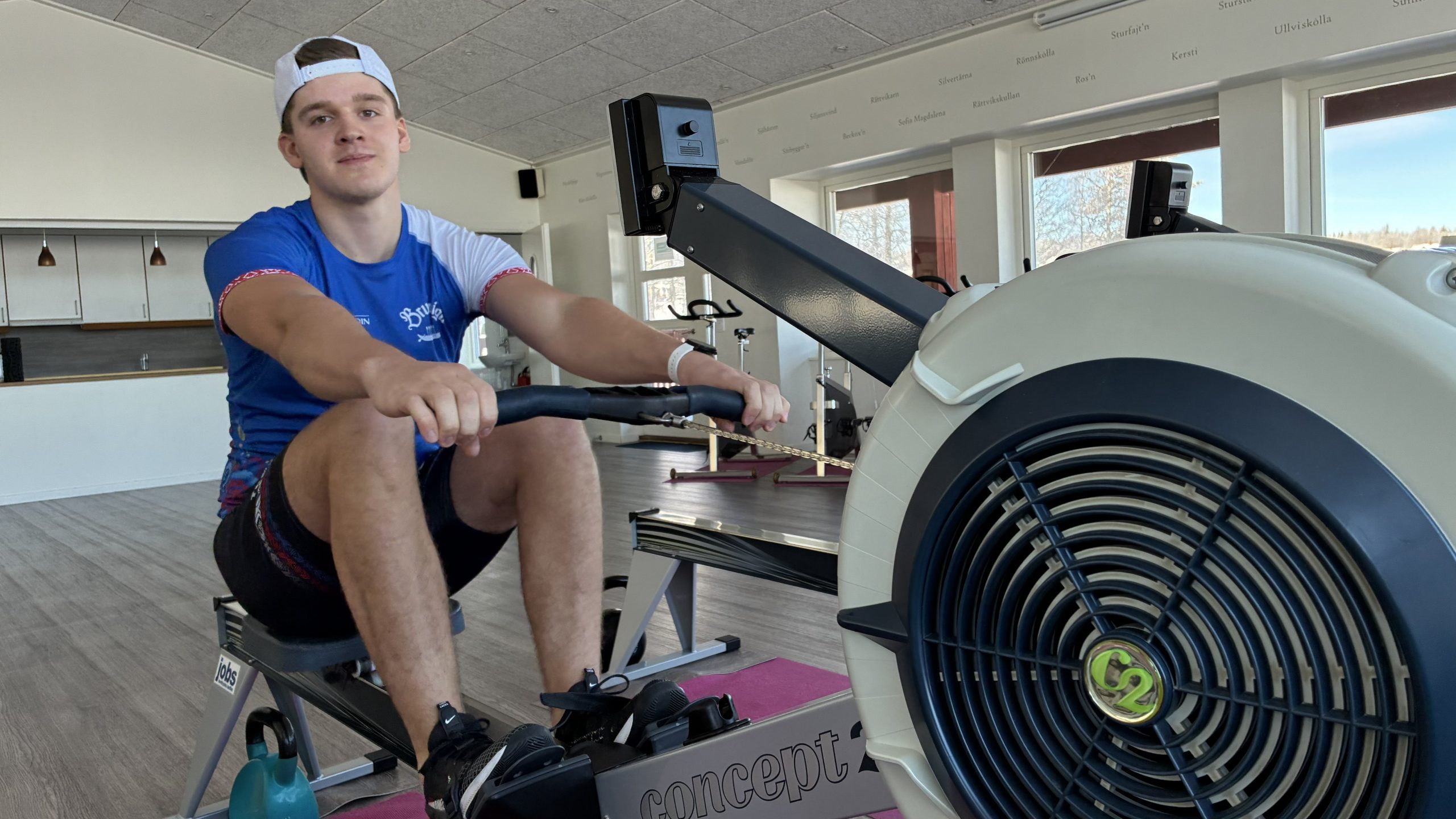 Alfred Änges sitter på roddmaskinen och drar handtaget mot sig.