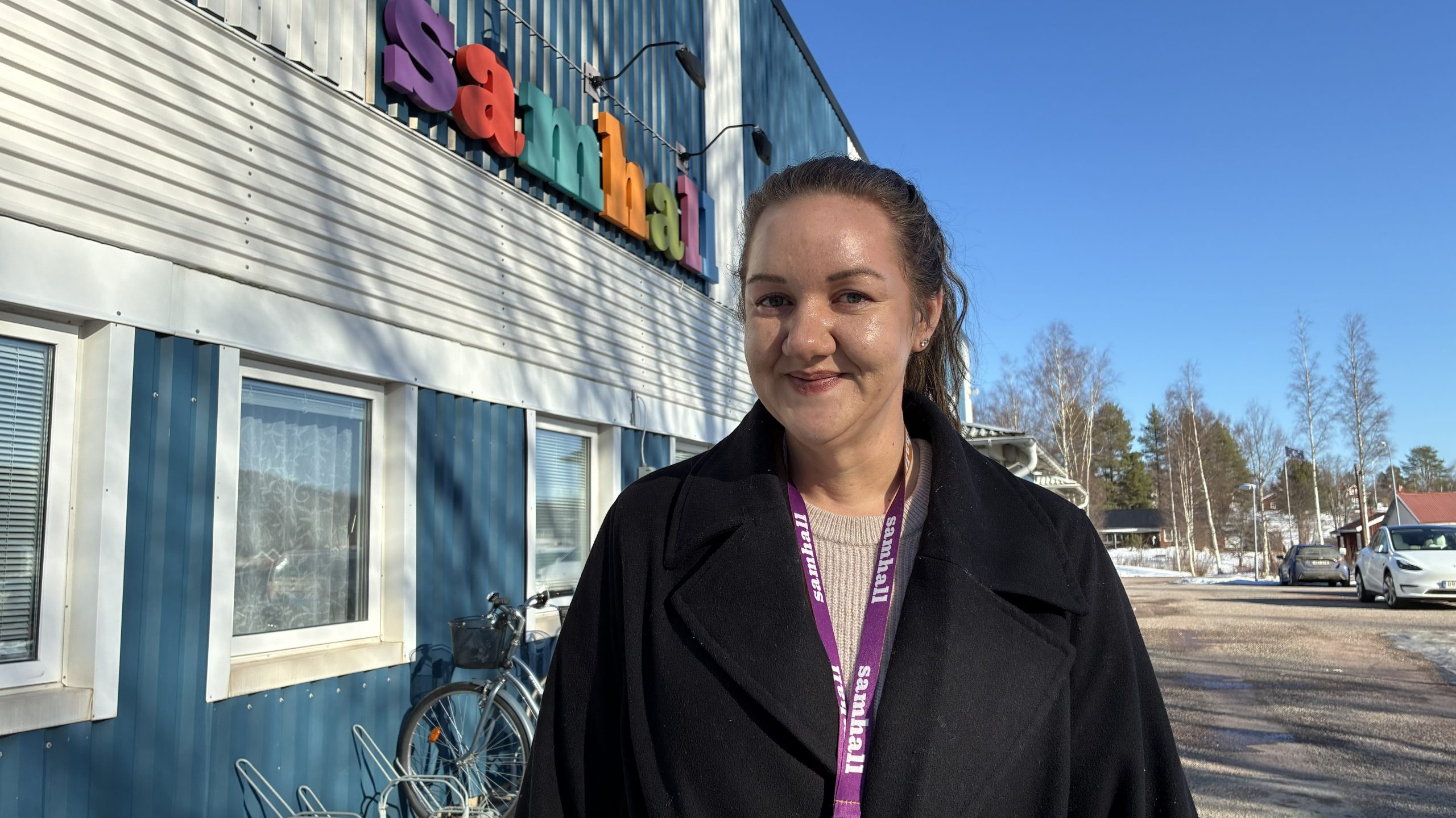 Linnéa Åslin uppställd framför Samhall-skylten i Leksand på en solig dag.