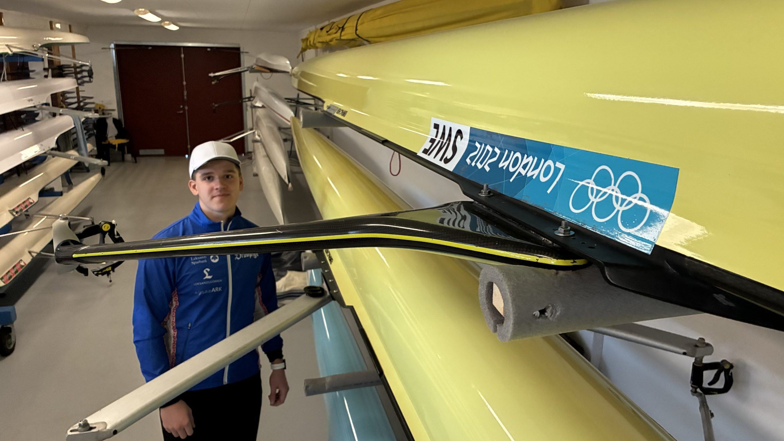 Alfred Änges står bredvid en måt som har ett klistermärke med OS-logotypen och texten London 2012.