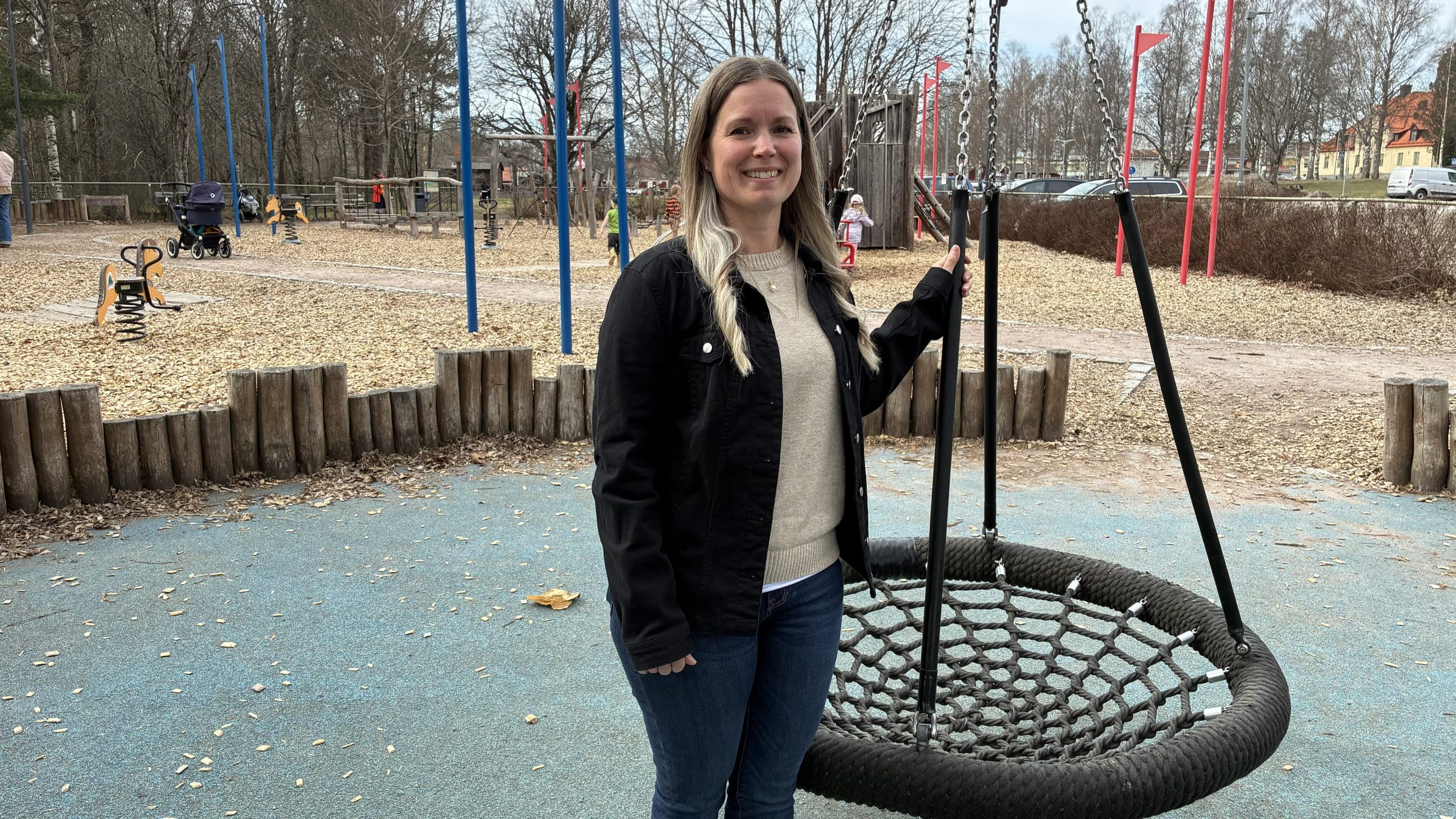 Kvinna står bredvid en kompisgunga.
