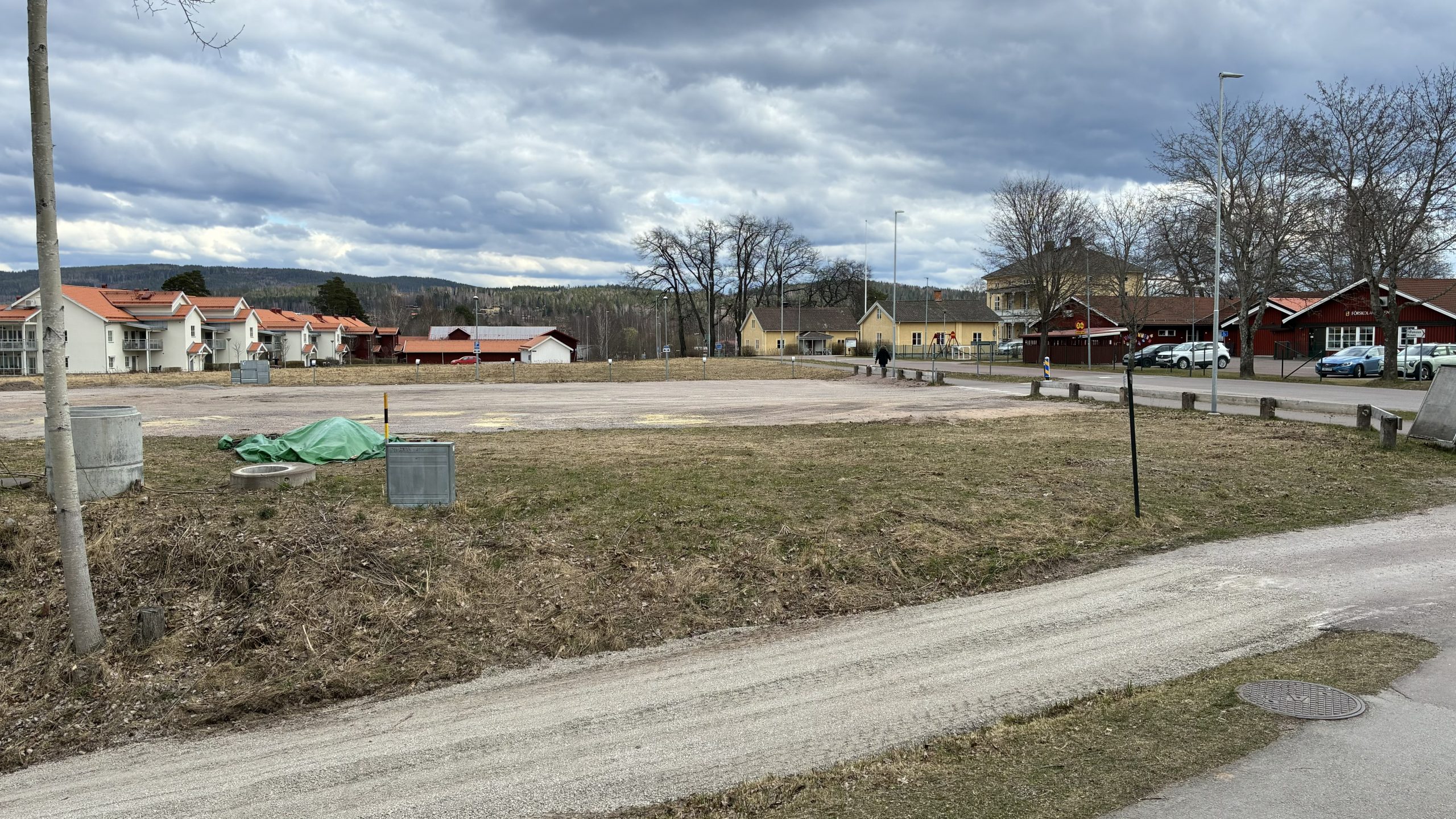 Tom grusparkering i molnigt vårväder.