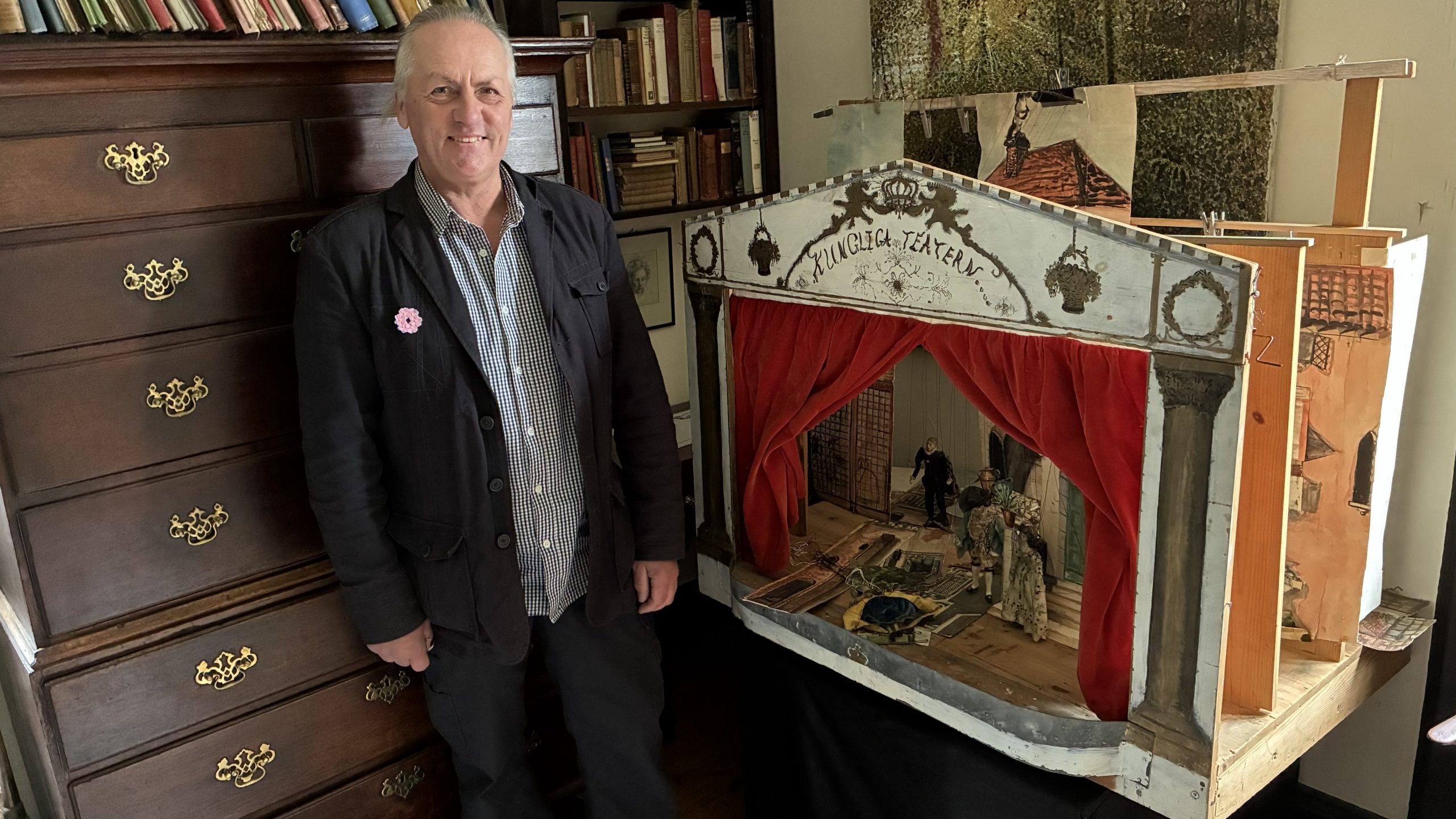 Man står intill en tjusig marionett-scen med överskriften "Kungliga Teatern".