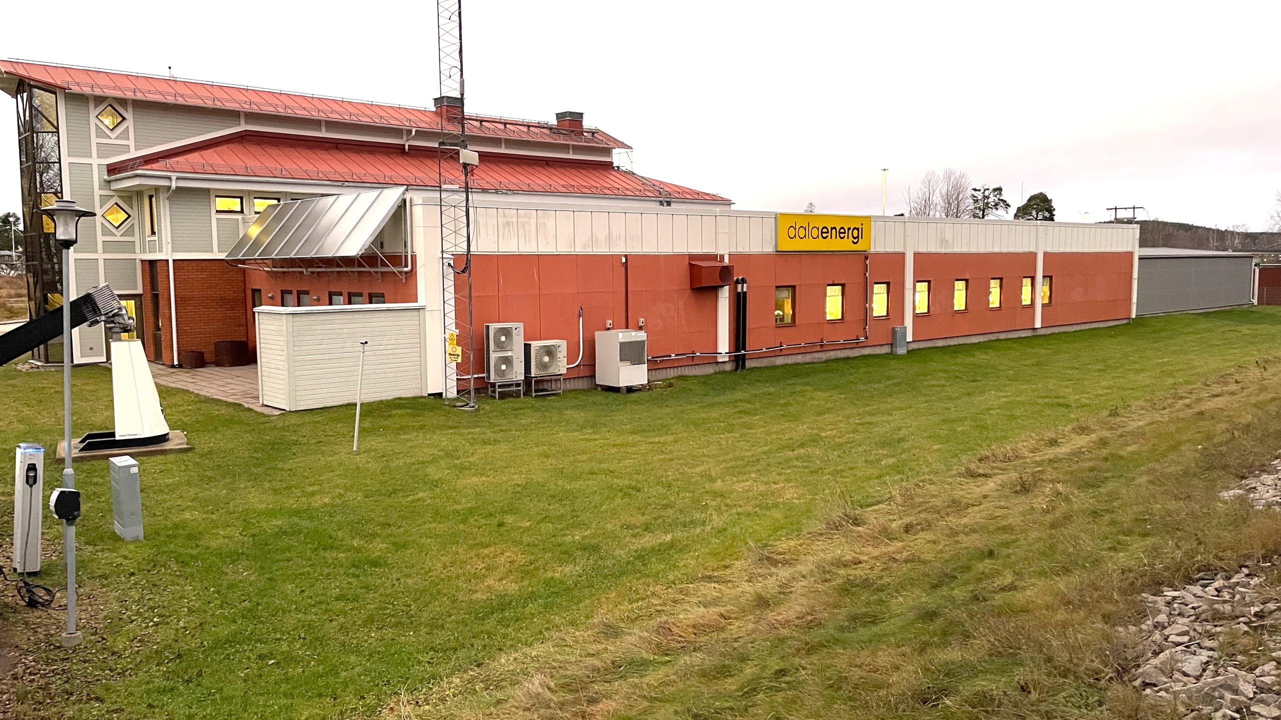 Exteriörbild på Dala Energis byggnad med en gul skylt med texten Dala Energi.