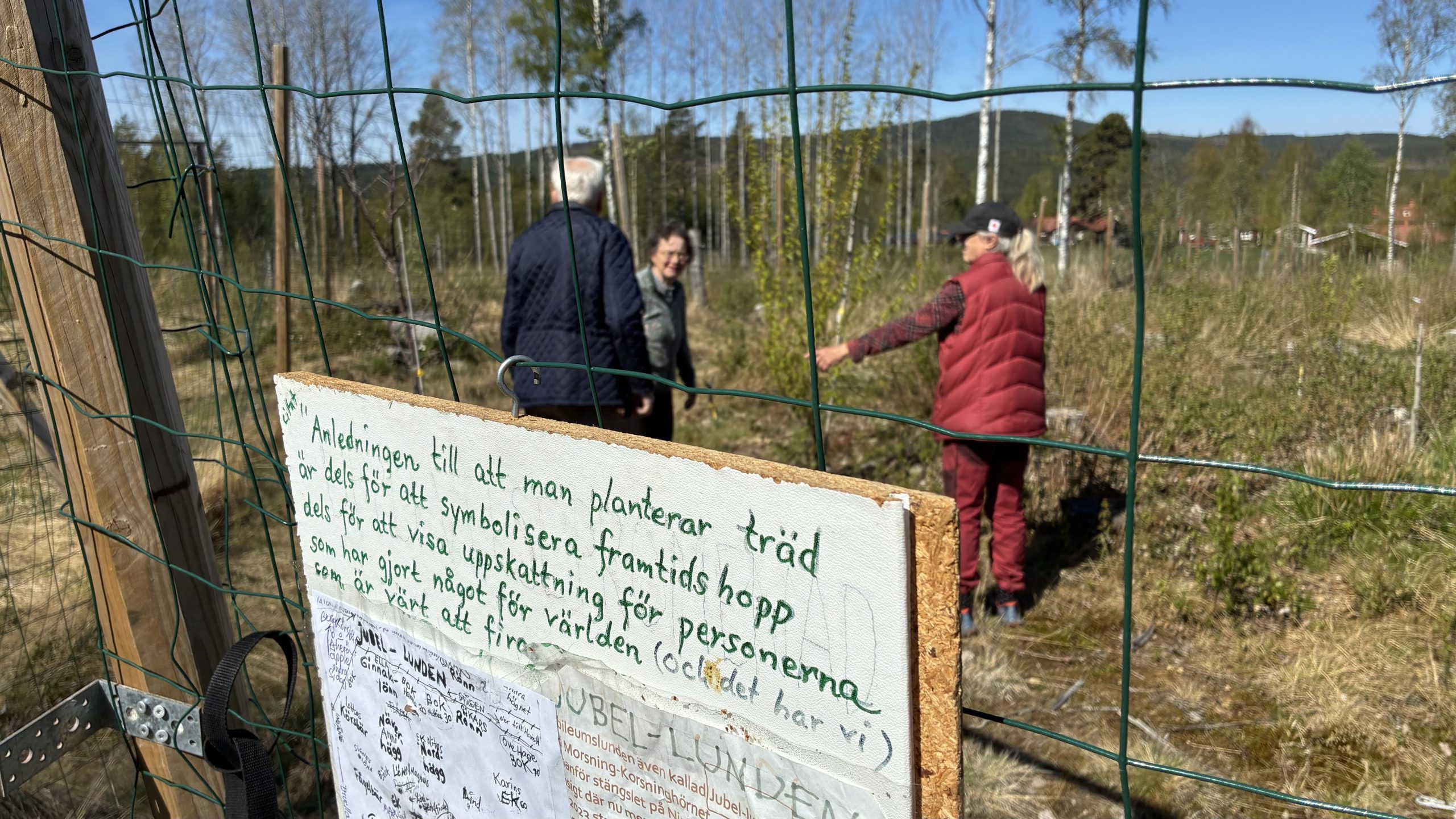 På skylten till hägnet står texten: "Anledningen till att man planterar träd är dels för att symbolisera framtidshopp, dels för att visa uppskattning för personerna som har gjort något för världen som är värt att firas".