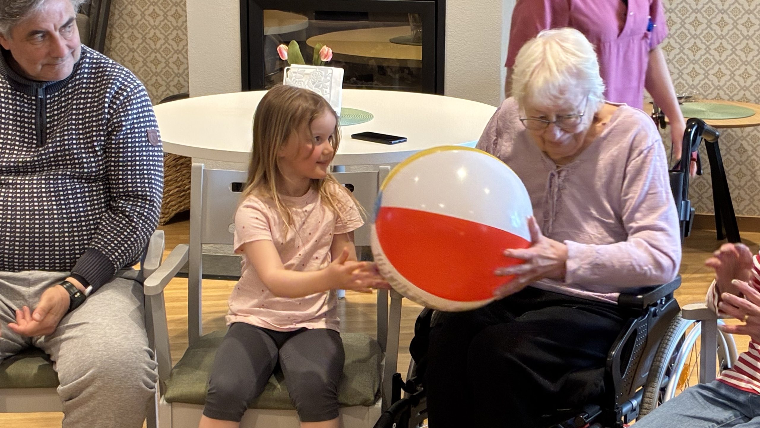 Flicka i förskoleåldern lämnar över en badboll till nästa person.