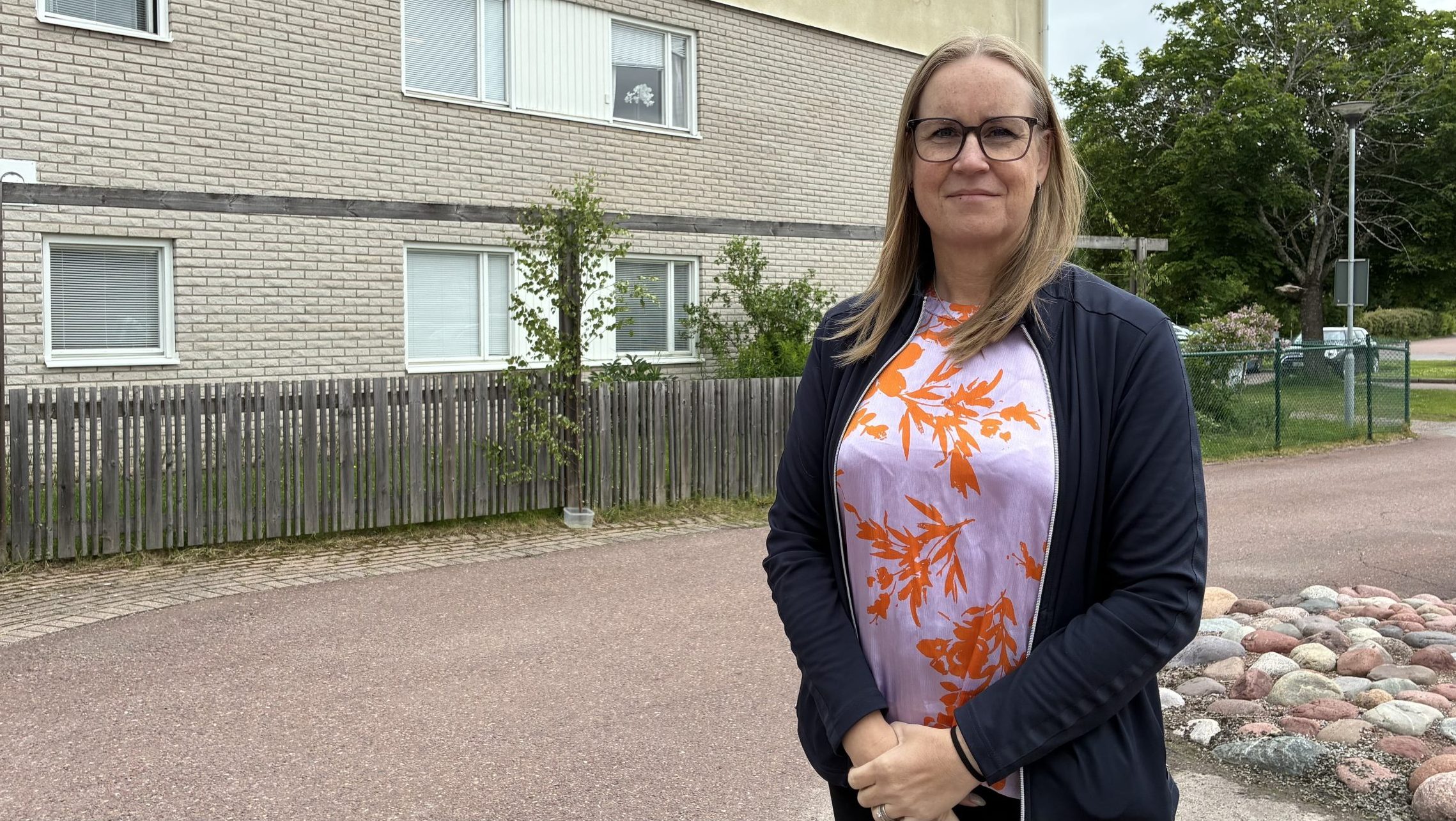Kvinna står framför husvägg med texten Edshultsgården.