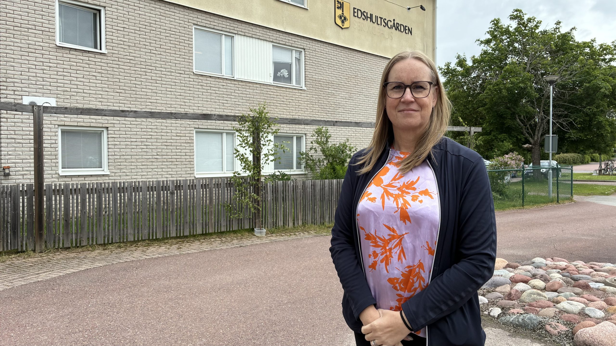 Kvinna står framför husvägg med texten Edshultsgården.