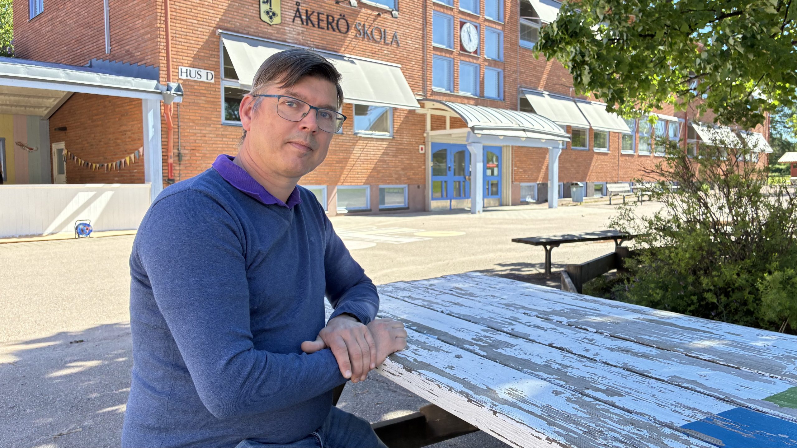 Johan Fändriks sitter på en bänk på skolgården utanför Åkerö skola.