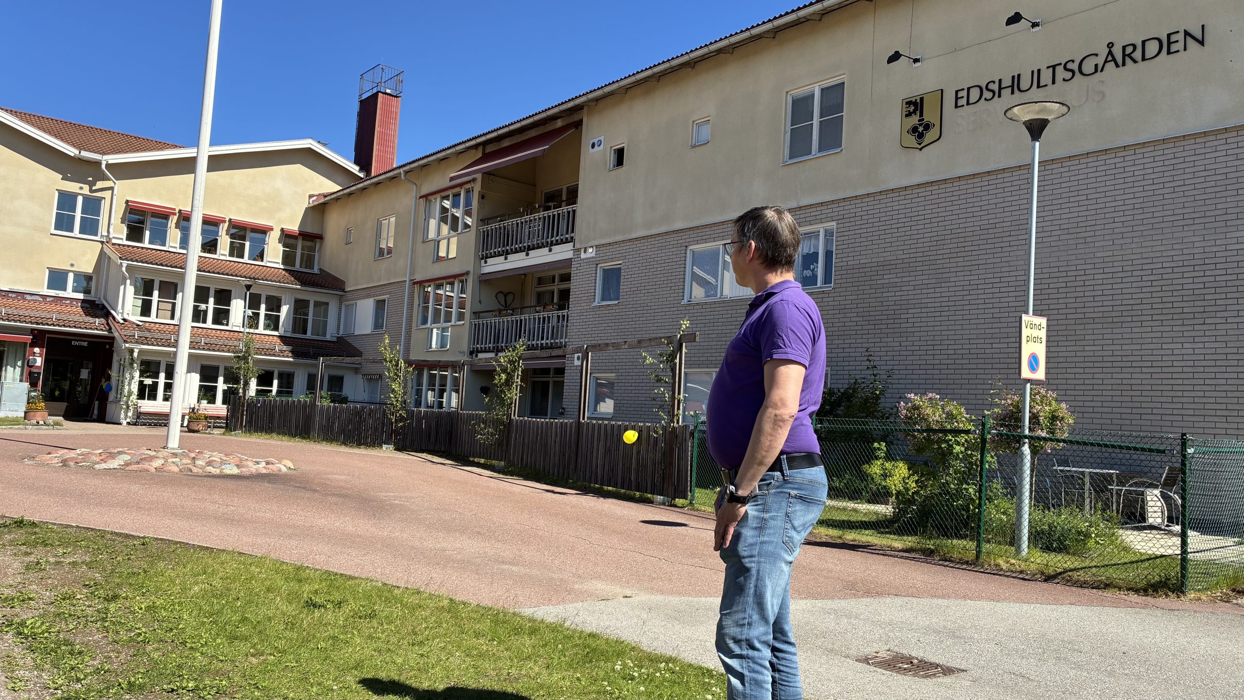 Johan Fändriks står vänd halvt bort från kameran och tittar mot ingången till Edshultsgårdens särskilda boende.