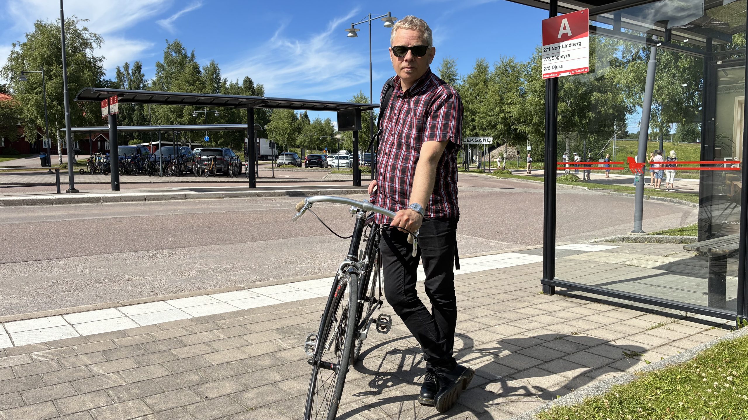 Markus Kummu står lutad mot en cykel vid busshållplatserna på Leksands resecentrum.