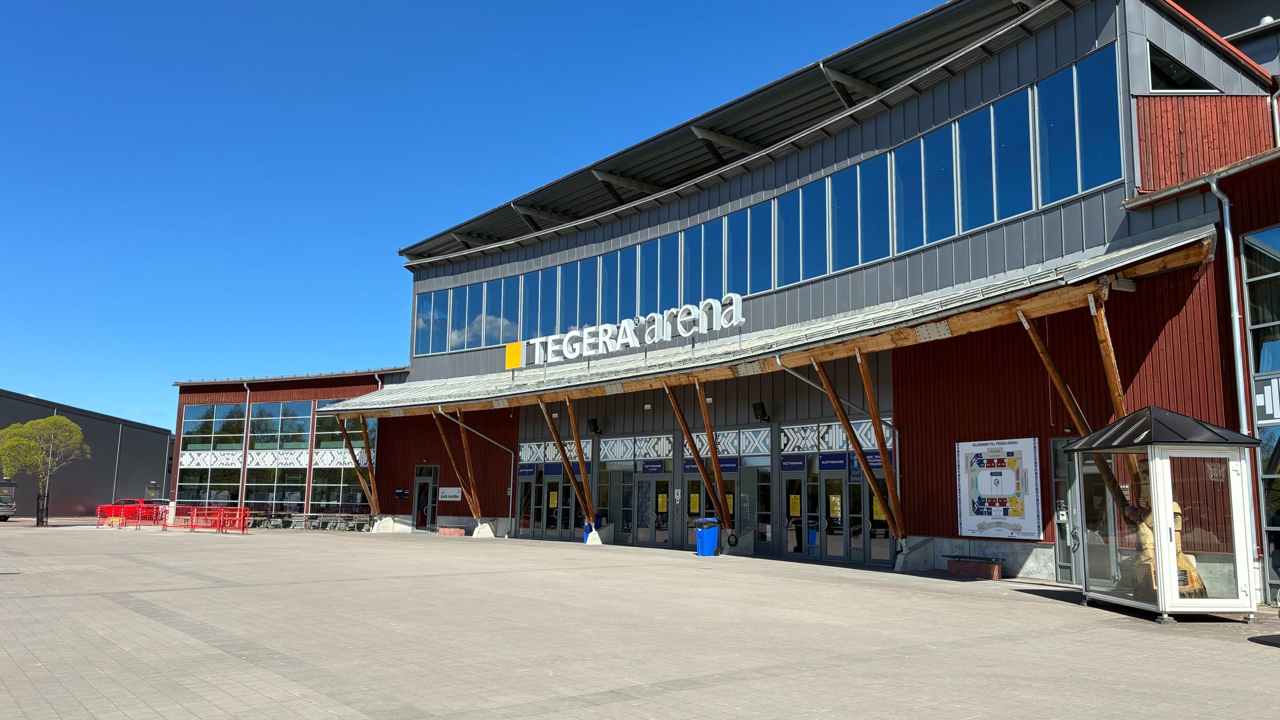 Exteriörbild på Tegera Arenas entré med blå himmel ovanför.