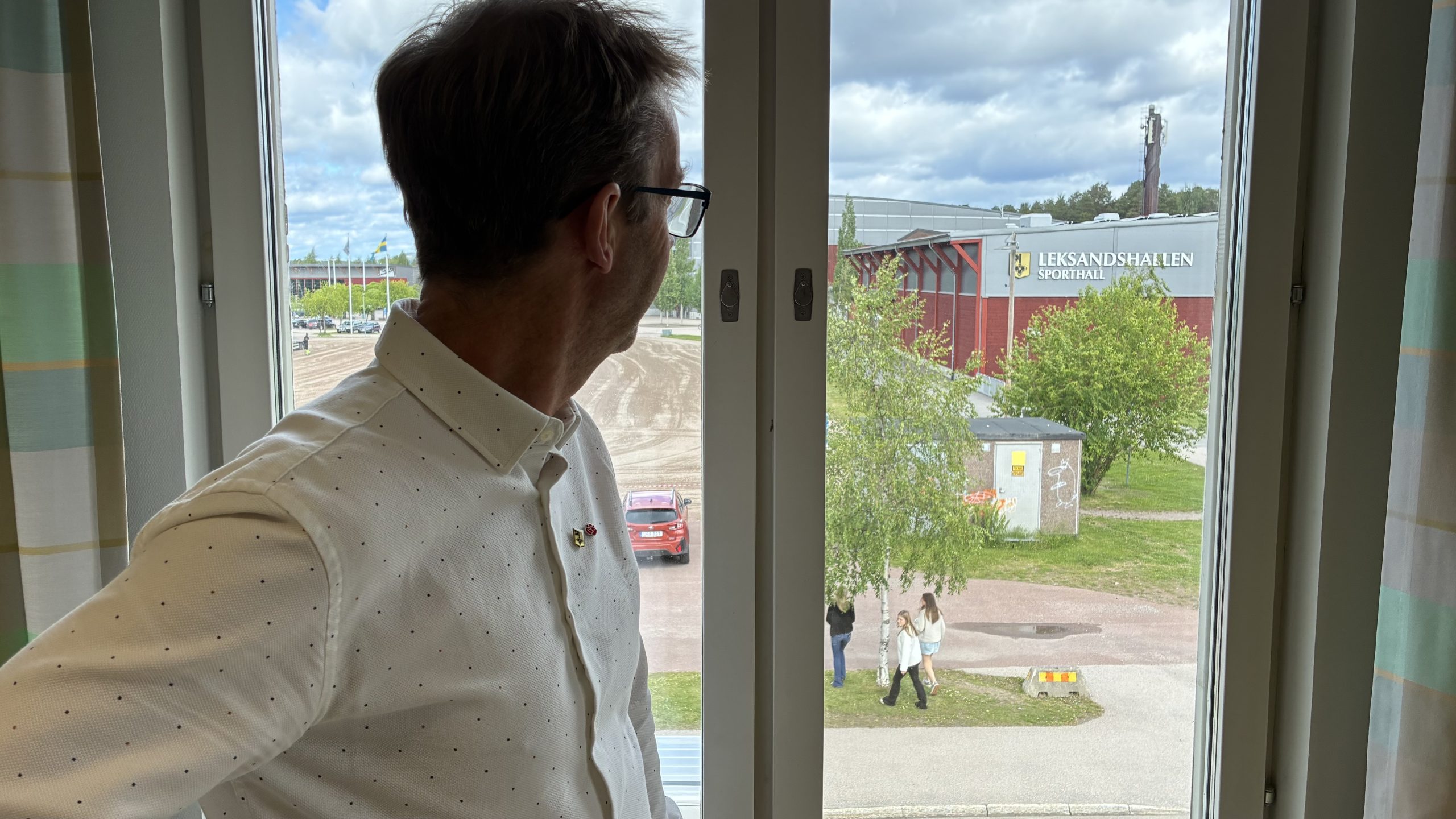 Lars Halvarson tittar ut genom ett fönster så att den relativt nya Leksands sporthall syns i bakgrunden.
