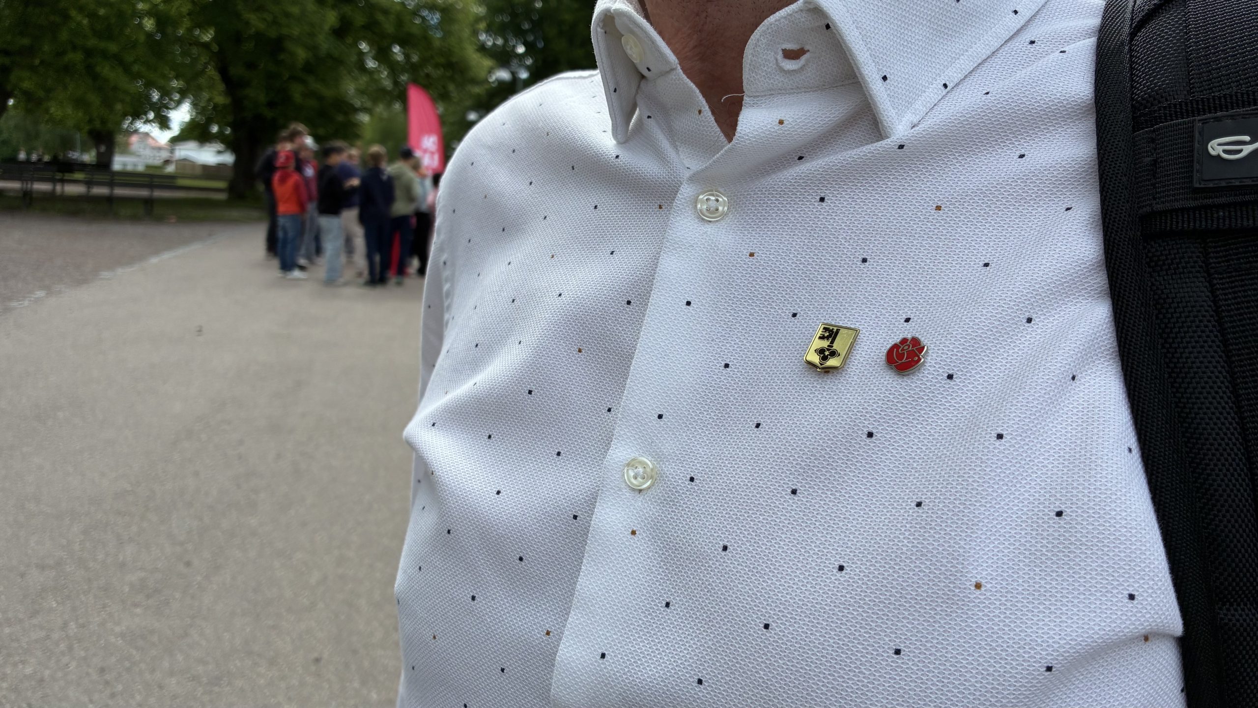 Närbild på skjorta med Socialdemokraternas och Leksands kommuns emblem.