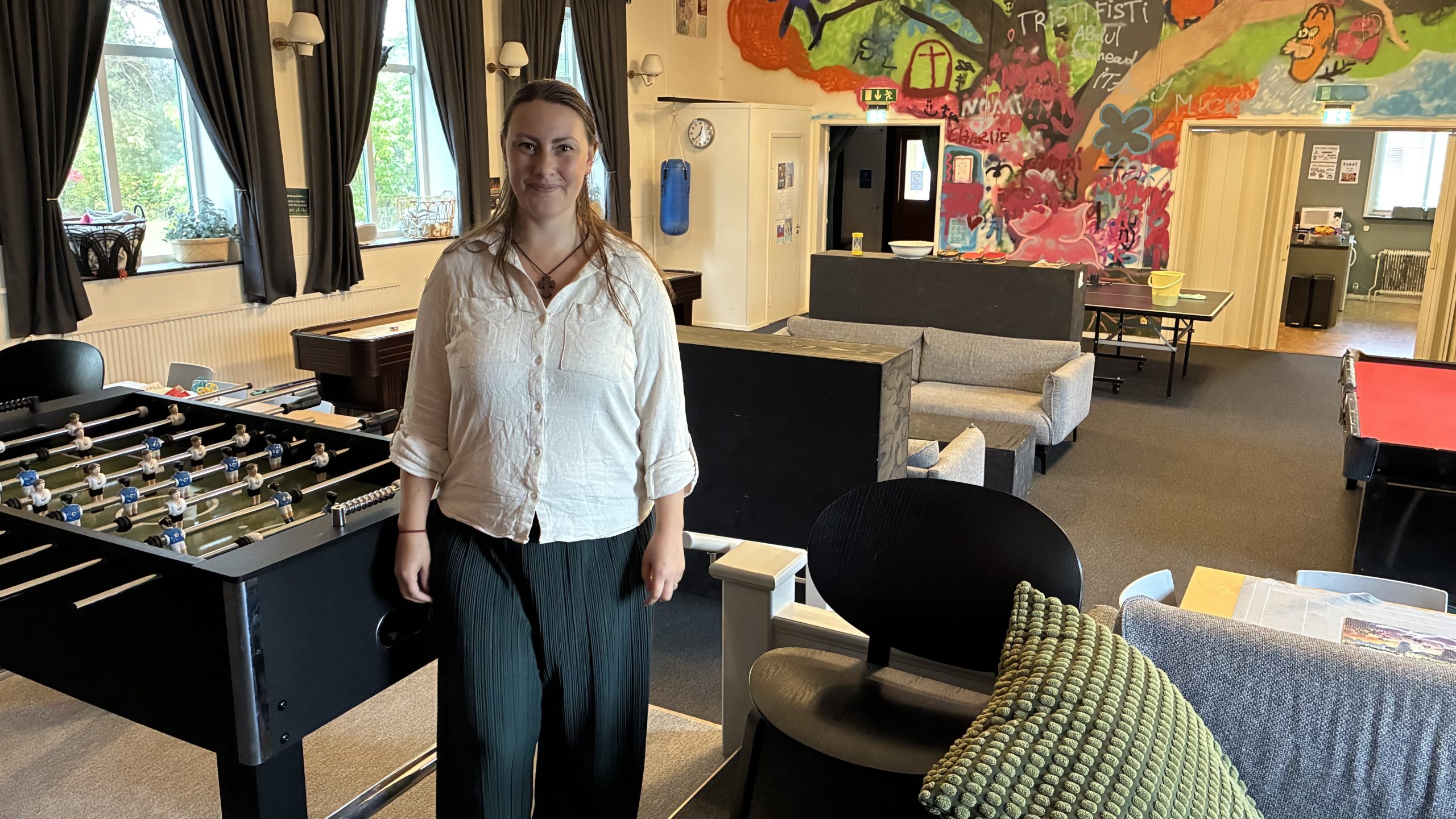 Anna Wedel Allgulin står uppställd bredvid ett fotbollsbord, med utsikt över resten av ungdomsgården.