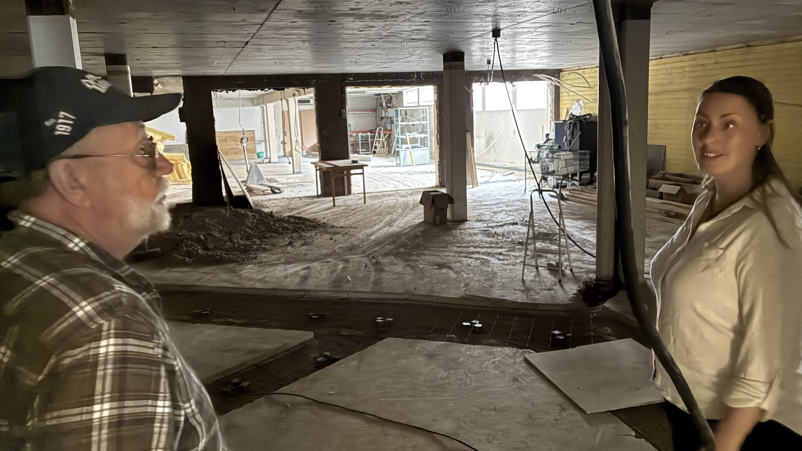 Utblick över ett kalt och grått källarplan med hål i golvet och sladdar som hänger löst.