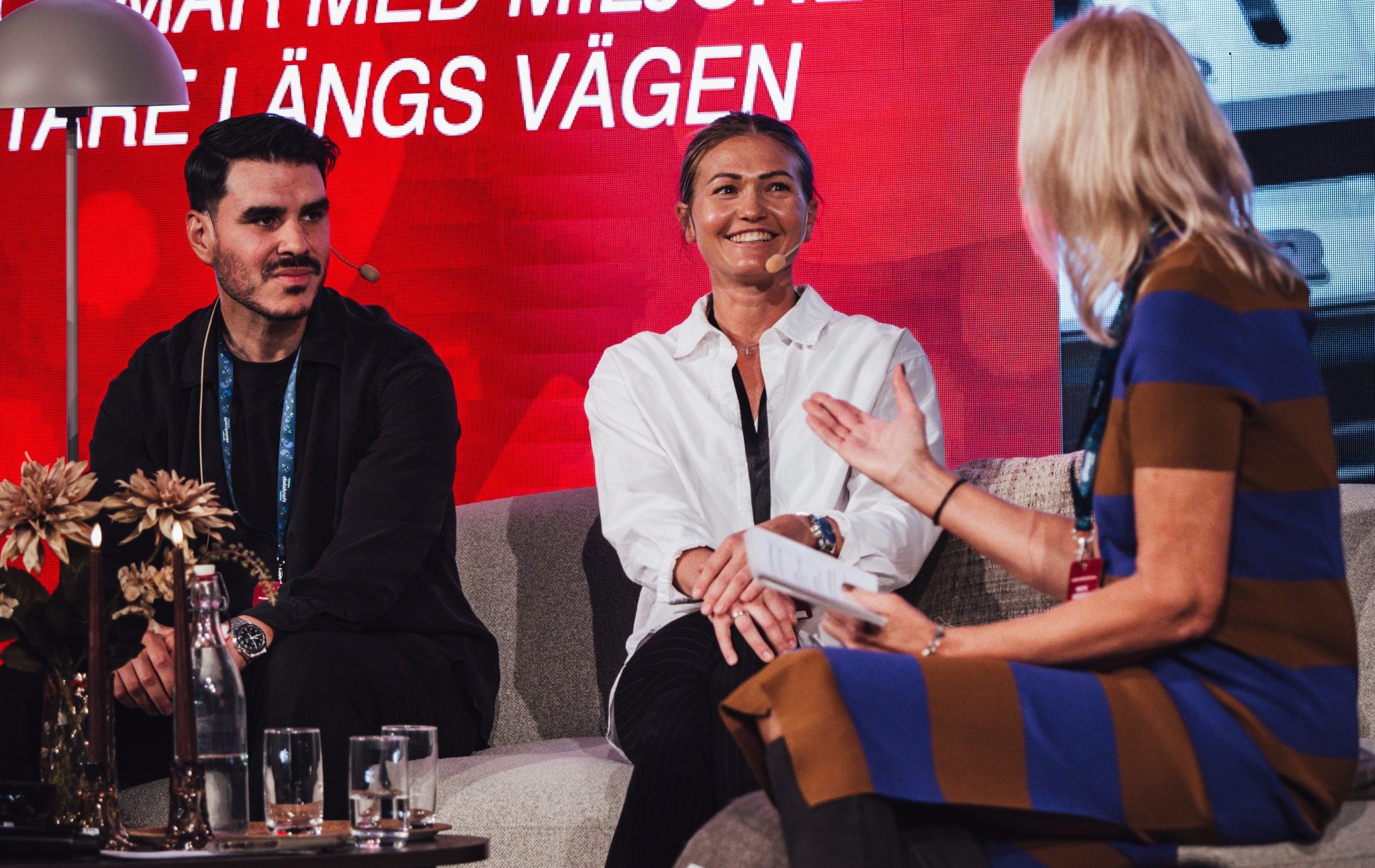 Glada personer i en soffa under ett panelsamtal