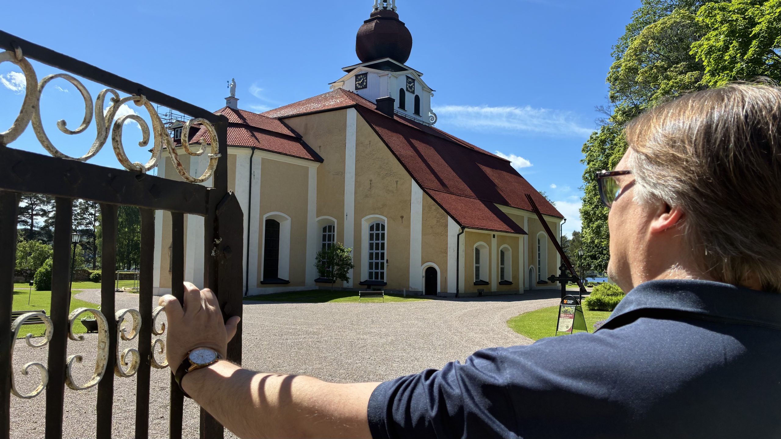 Fredrik Winberg håller upp grinden till Leksands kyrka, en av hans arbetsplatser.