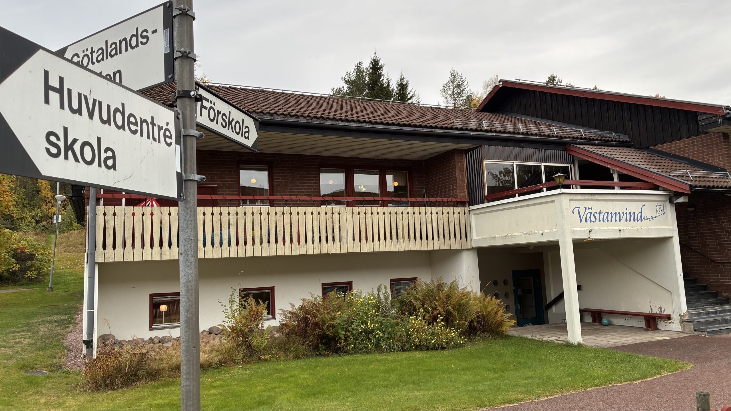 Exteriörbild som visar entrén till förskolan Västanvind, med vägvisningsskyltar närmast kameran.