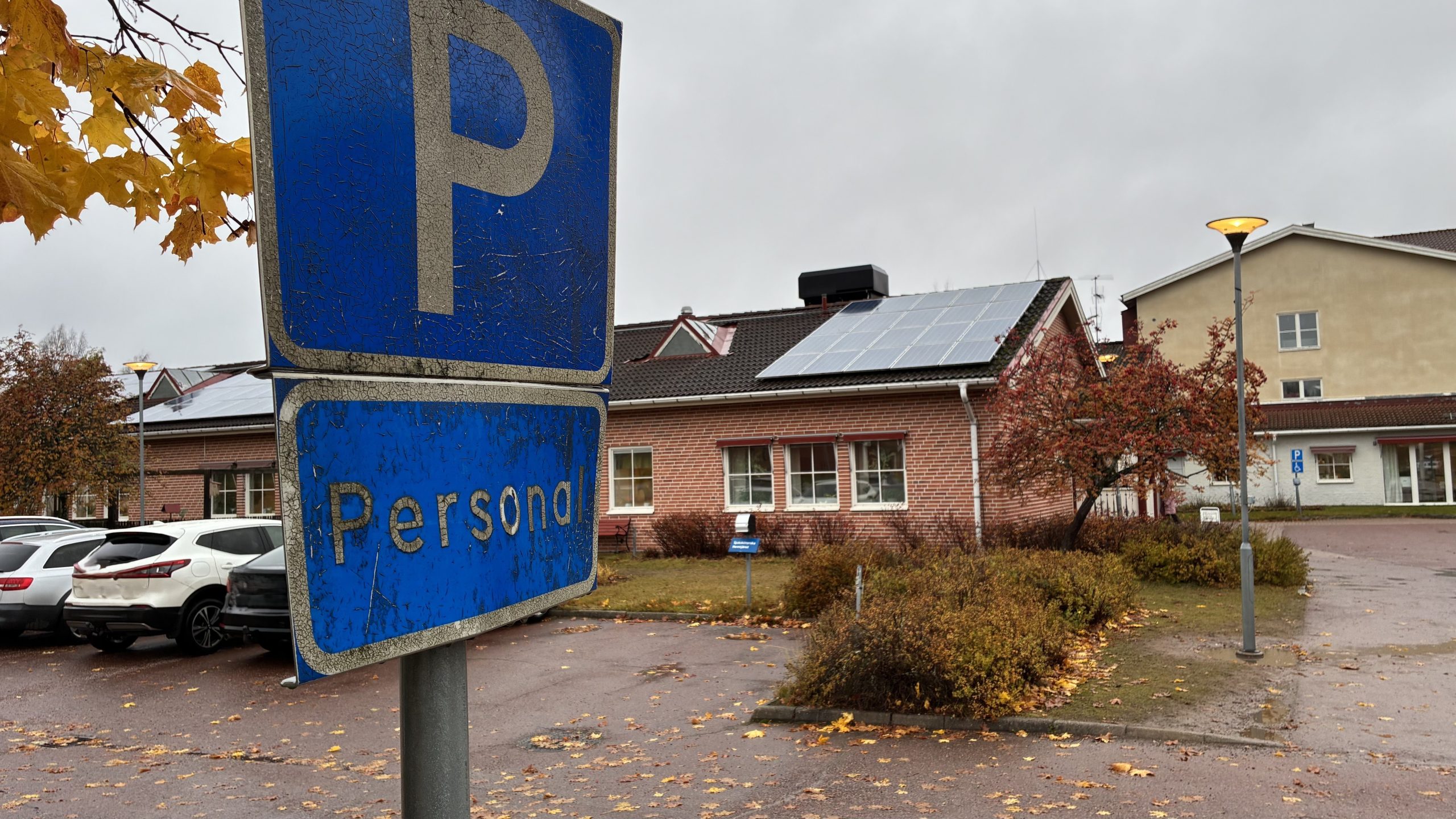 Närbild på skylt för personalparkering, med Edshults boende i bakgrunden.