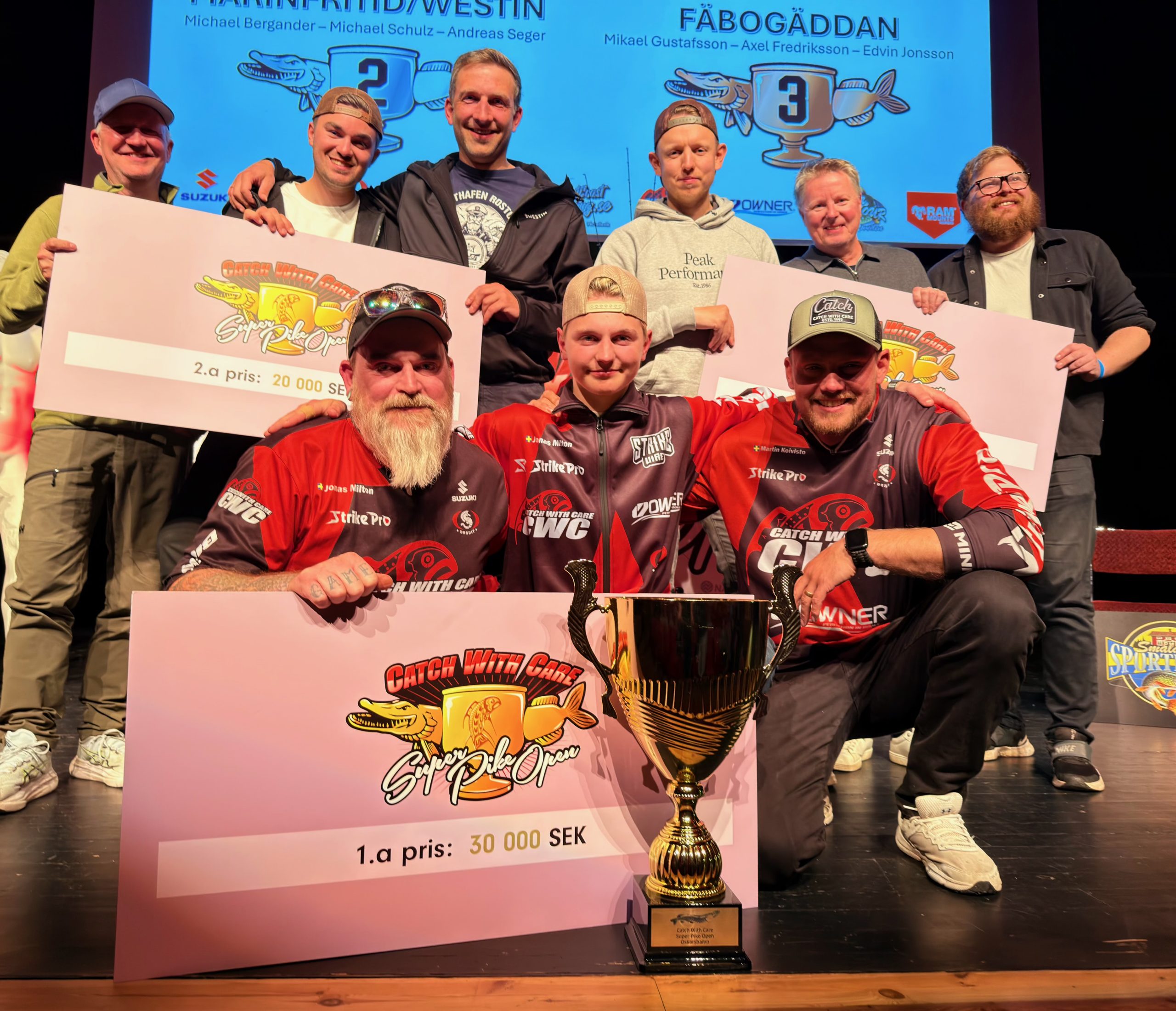 Bild från prisutdelningen där Max och lagkamraterna poserar med vinnarchecken och en stor pokal.